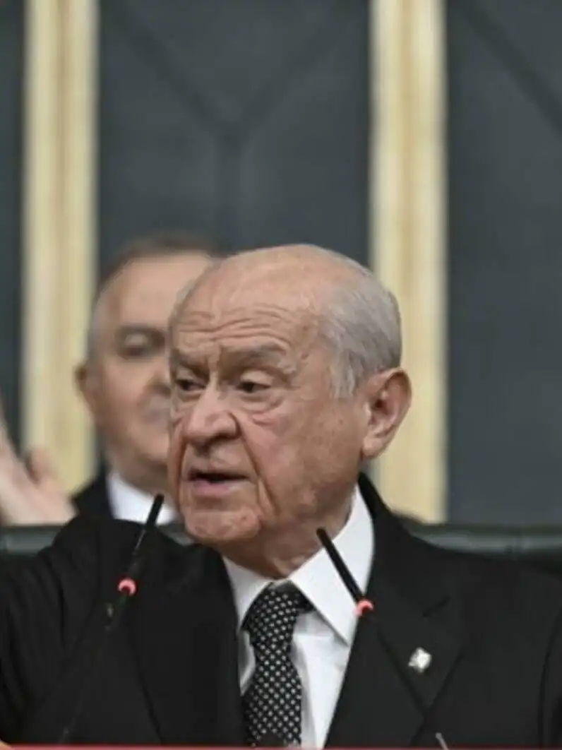 Devlet Bahçeli raising his hand while speaking.