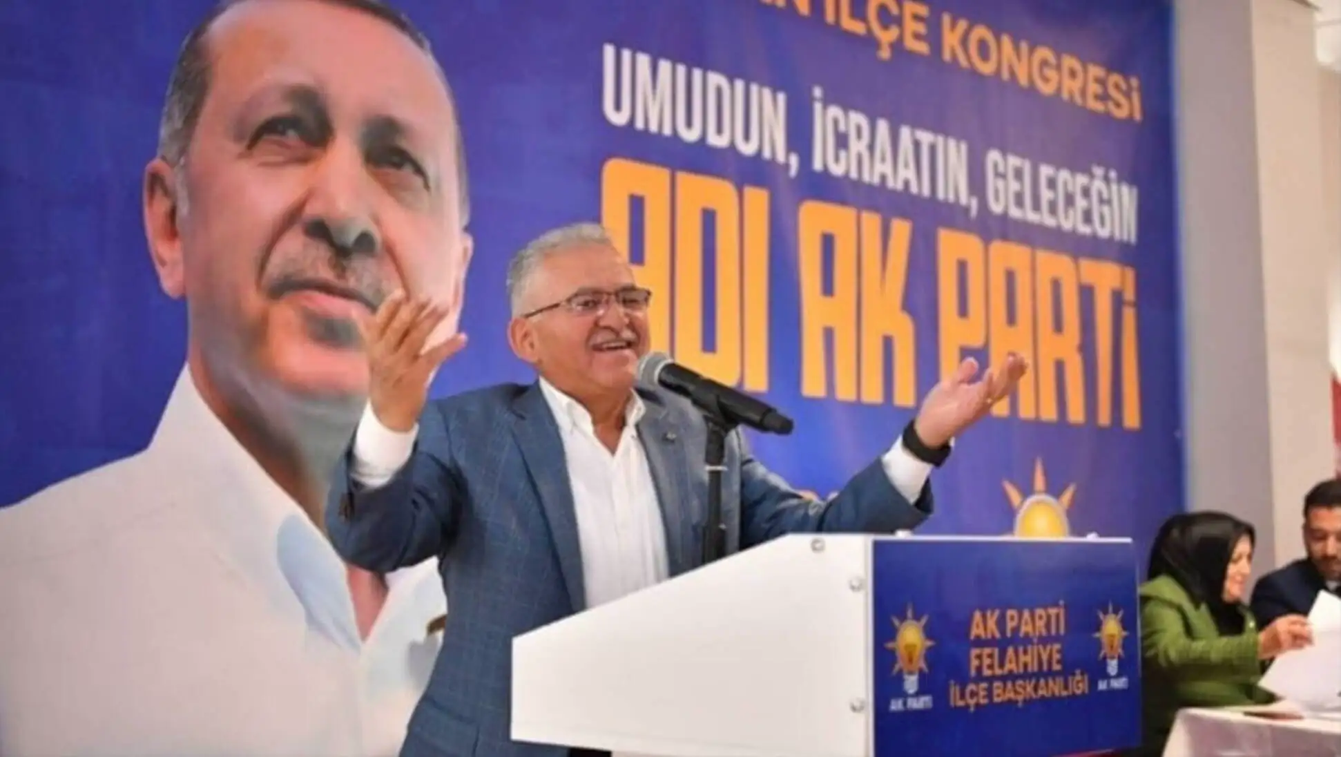 Bir adam bir podiumda mikrofonla konuşuyor. Bir adam bir podiumda mikrofonla konuşuyor.