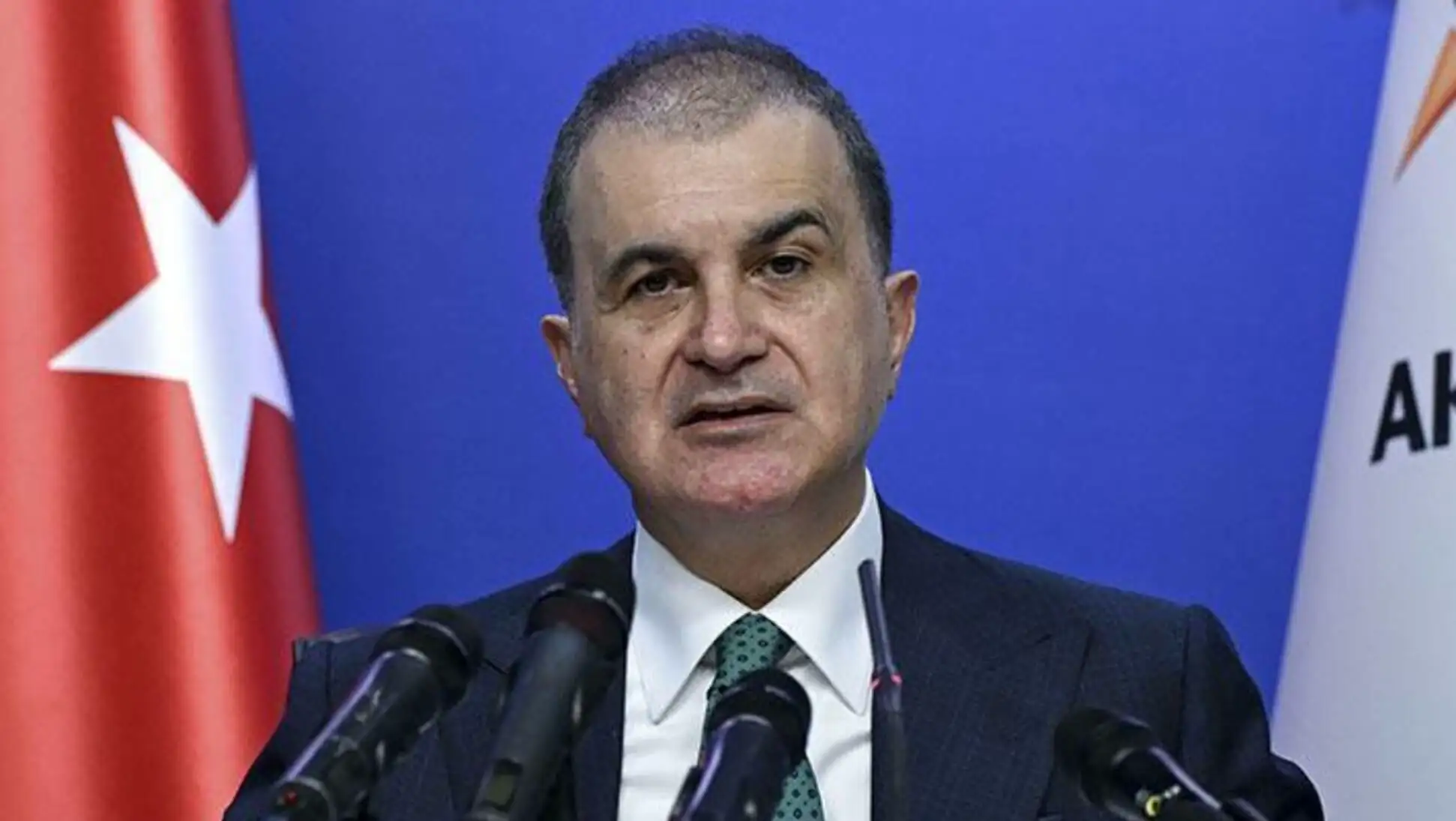 Bir adam, mikrofonların önünde duruyor.