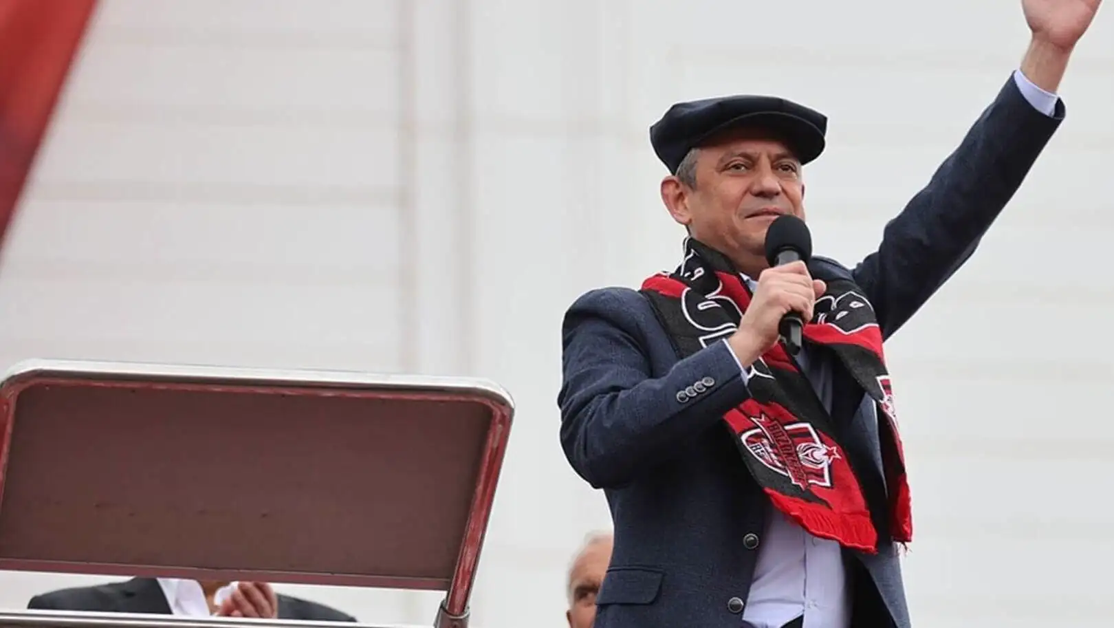 Mikrofon tutan ve elini kaldıran bir adam. Mikrofon tutan ve elini kaldıran bir adam.
