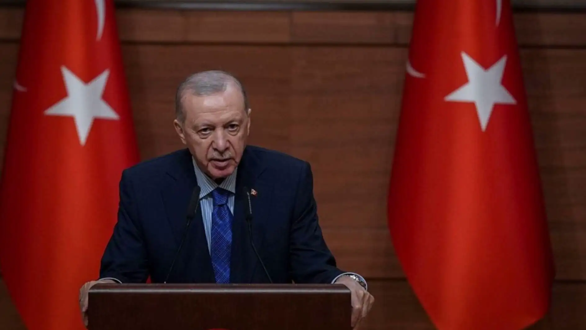 President Erdoğan speaking at a podium.