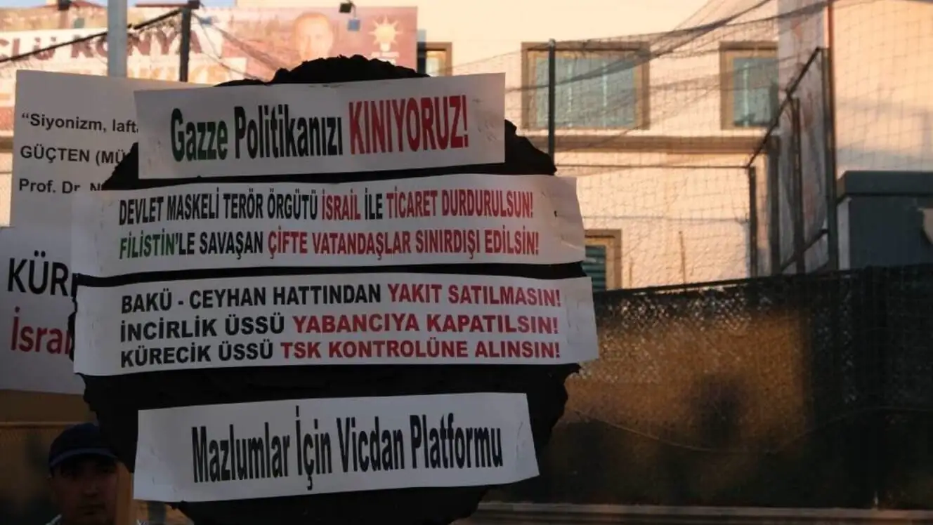 Bir adam, protesto sırasında pankart tutuyor. Bir adam, protesto sırasında pankart tutuyor.