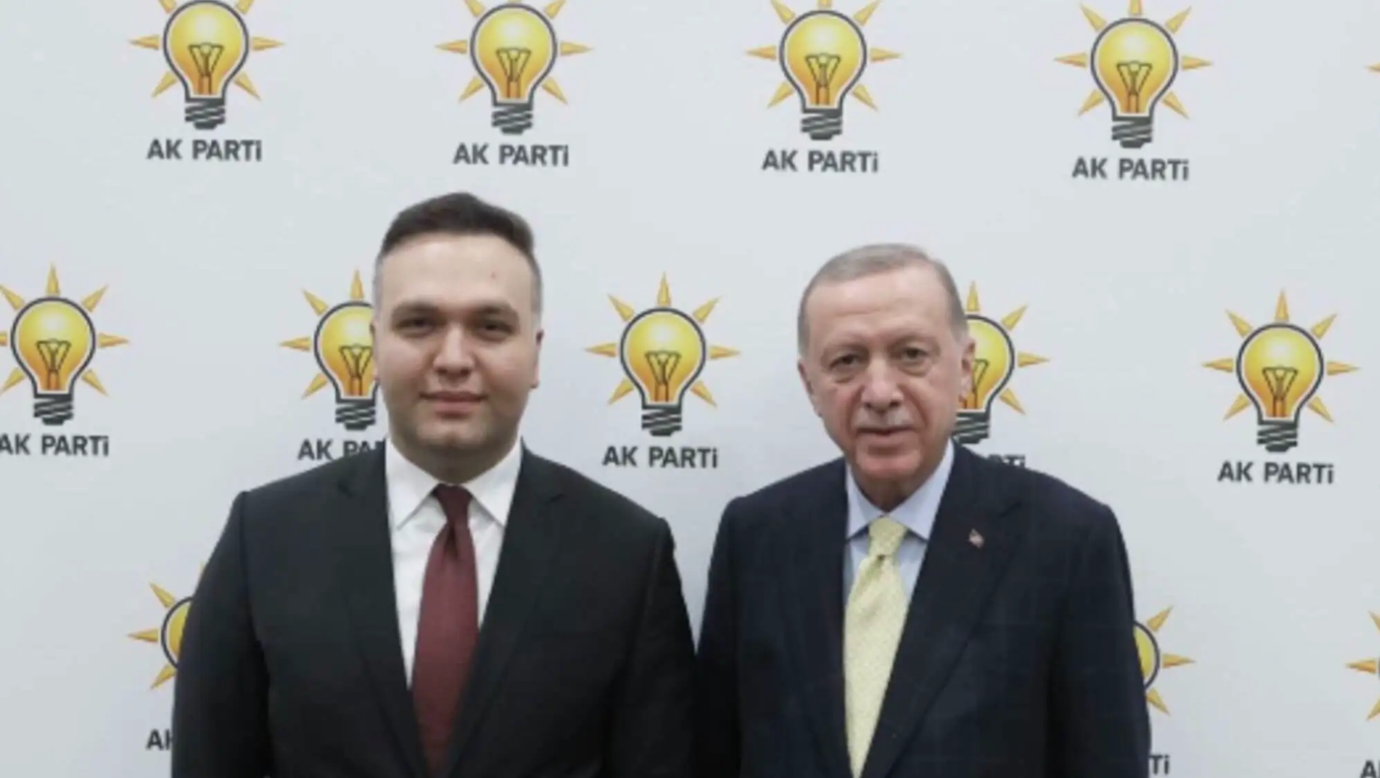 İki adam, ışık ampulleriyle dolu bir duvarın önünde duruyor. İki adam, ışık ampulleriyle dolu bir duvarın önünde duruyor.