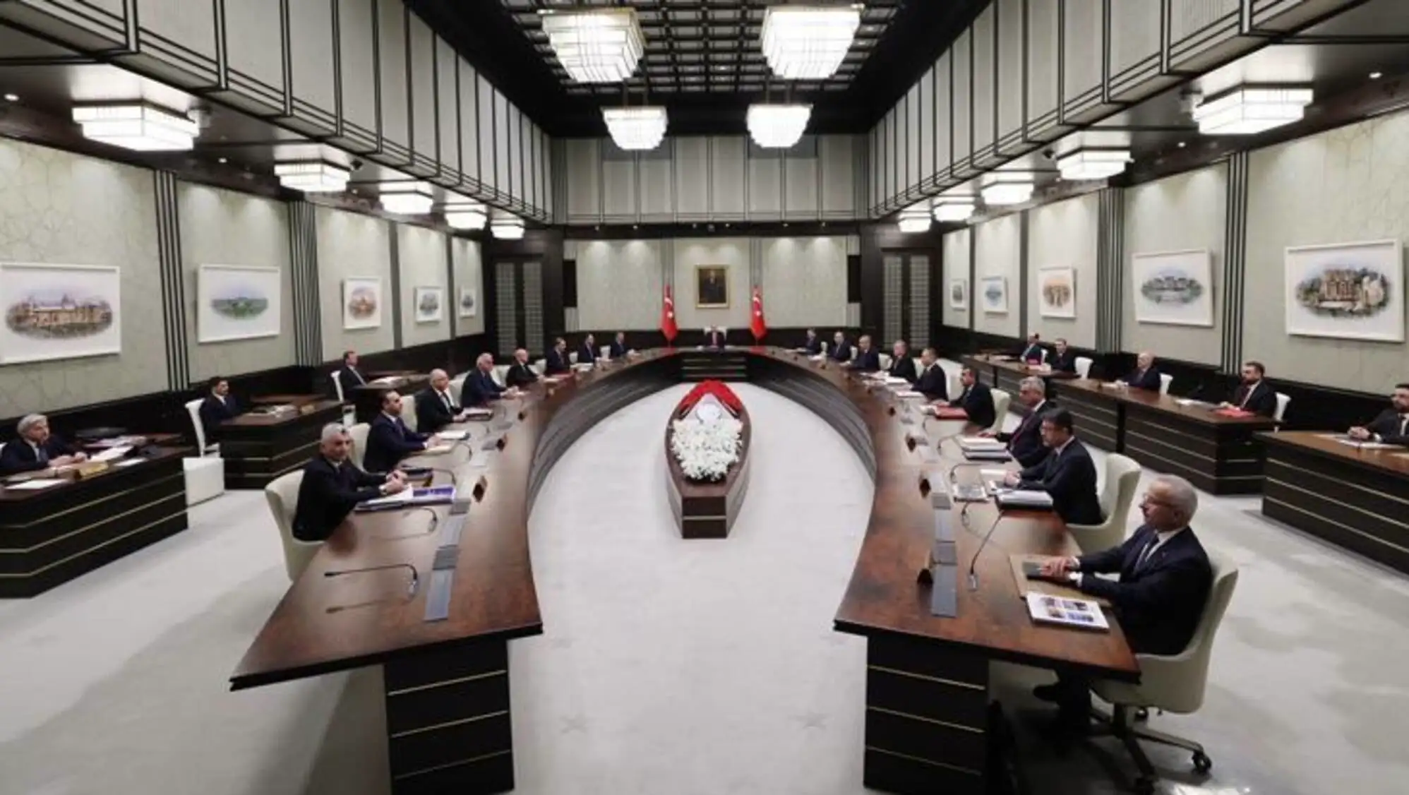 A group of people sitting at a table during the cabinet meeting.