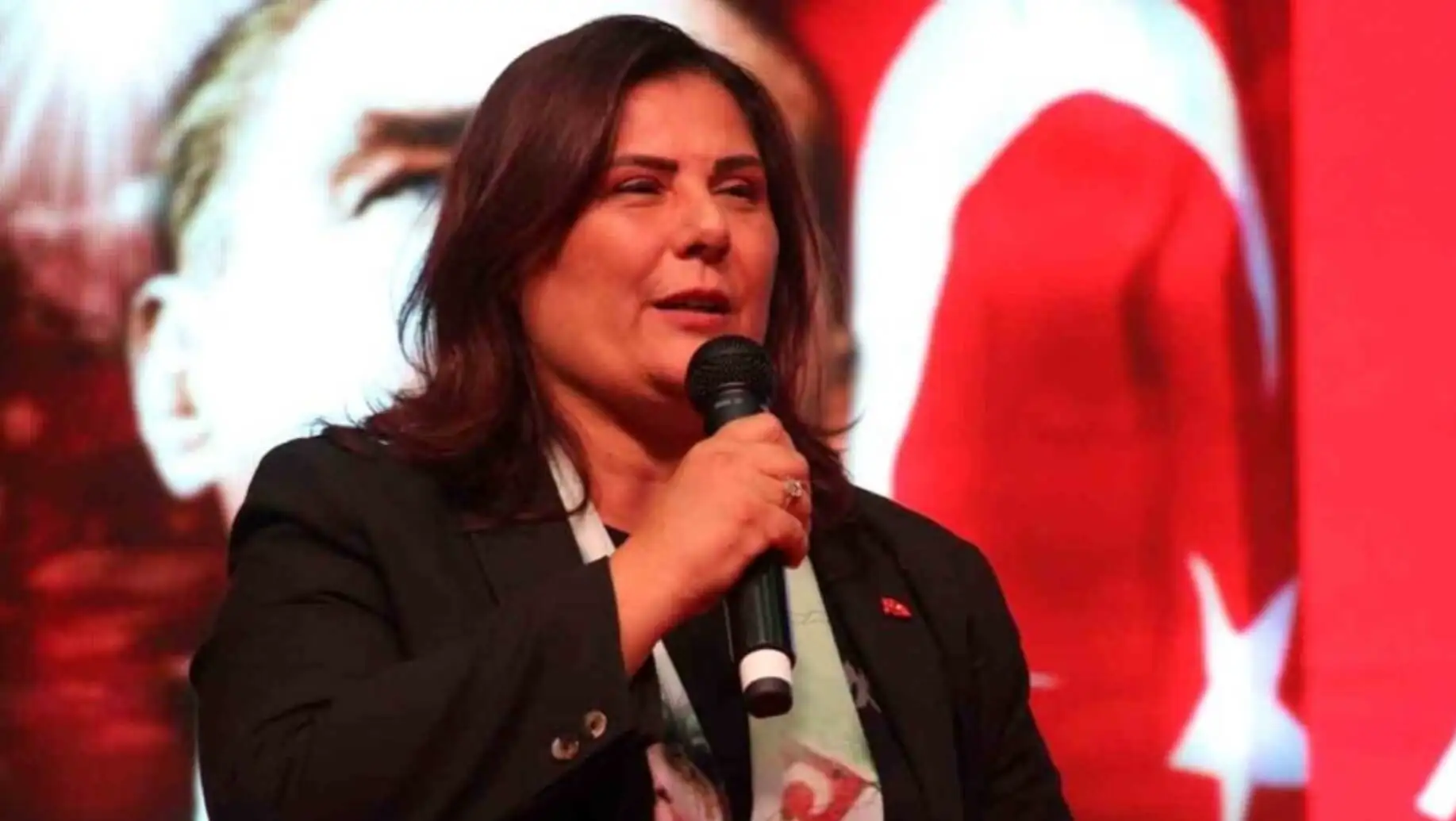 Bir kadın mikrofonla konuşuyor. Bir kadın mikrofonla konuşuyor.