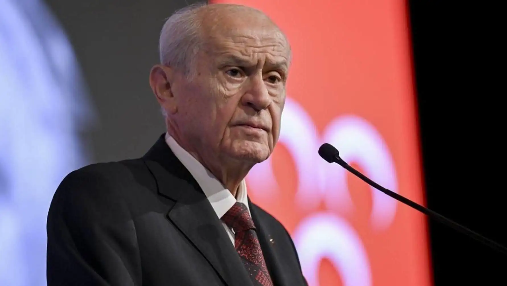 Mikrofonun önünde duran bir adam.