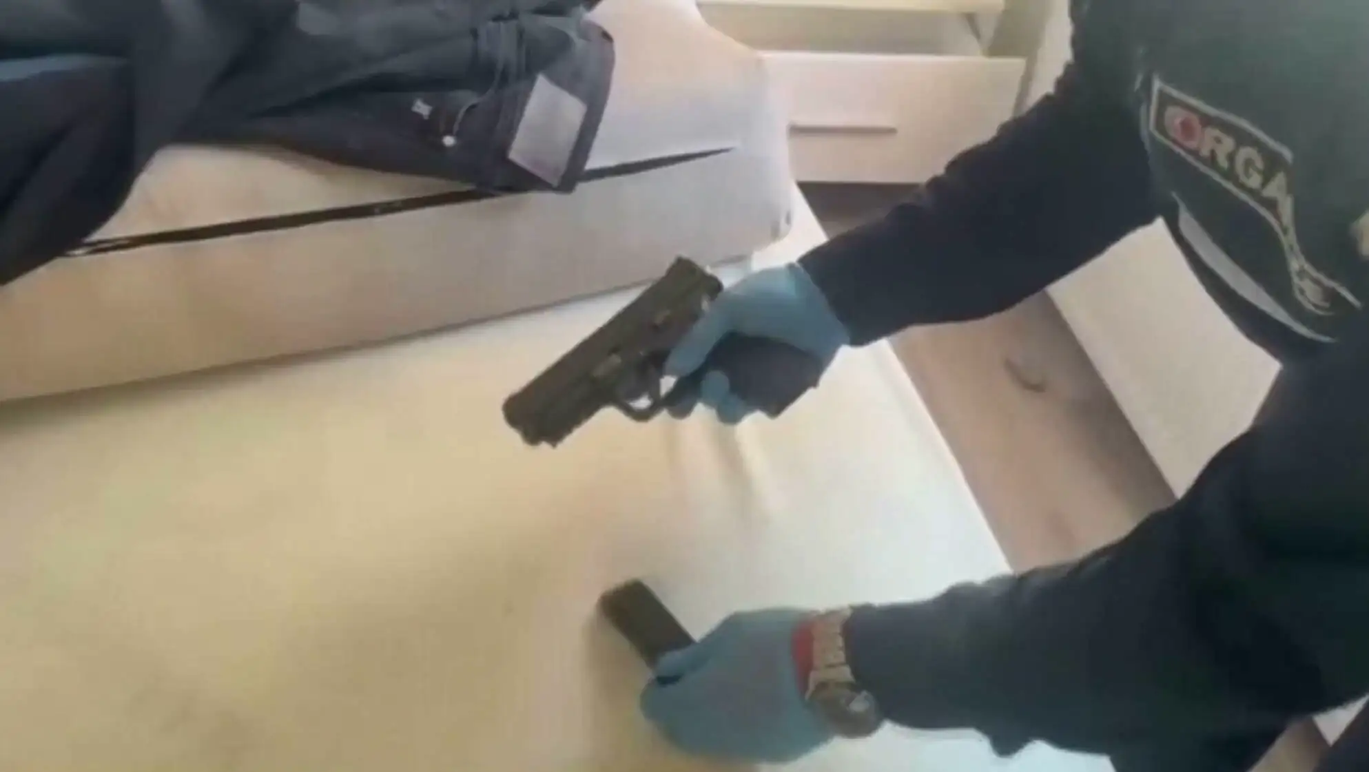 A person holding a gun. A person holding a gun.