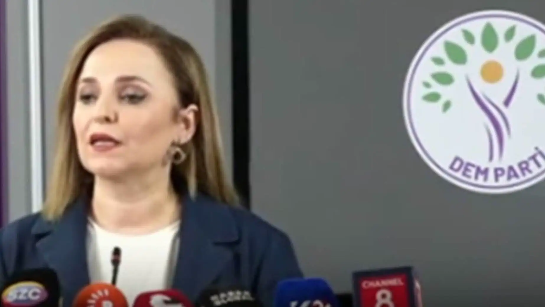 A woman speaking into microphones.