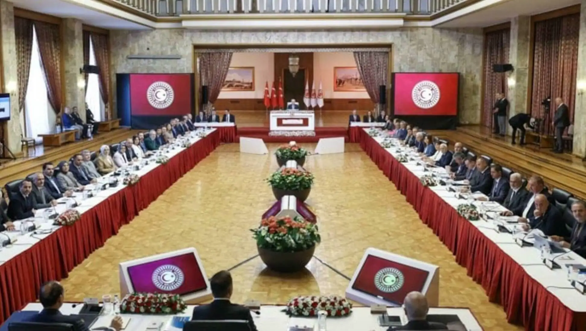 A group of people sitting at tables in the Parliament meeting. A group of people sitting at tables in the Parliament meeting.