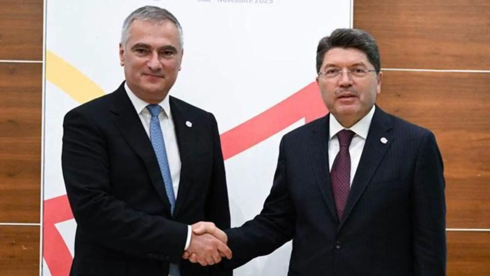 Bakan Tunç, mevkidaşlarıyla el sıkışıyor.
