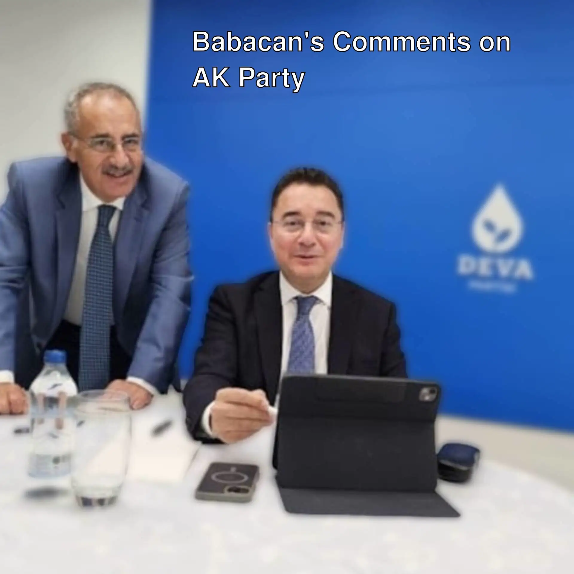 Ali Babacan and his assistant sitting at a table.