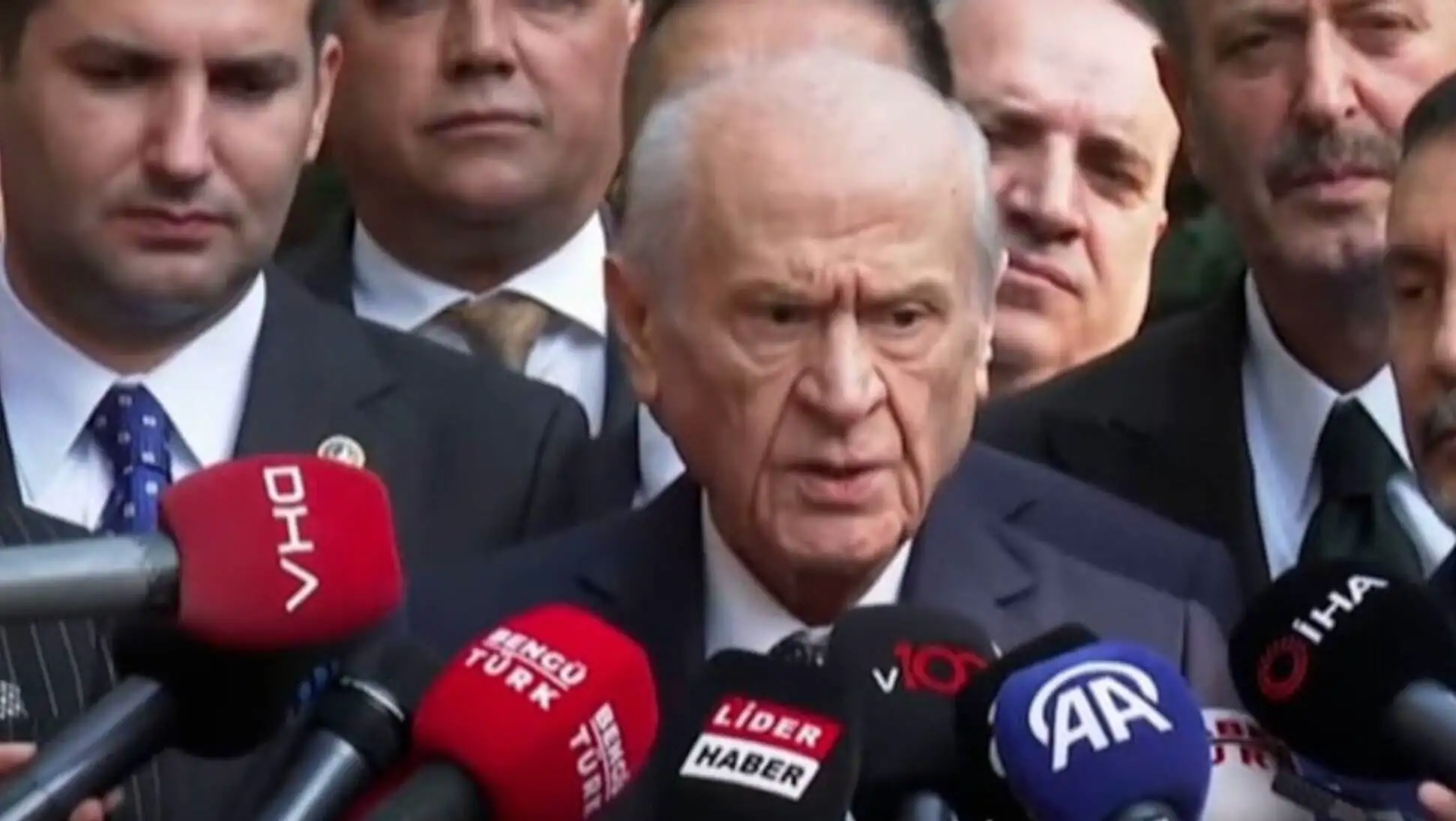 Devlet Bahçeli speaks into microphones during his important statements.