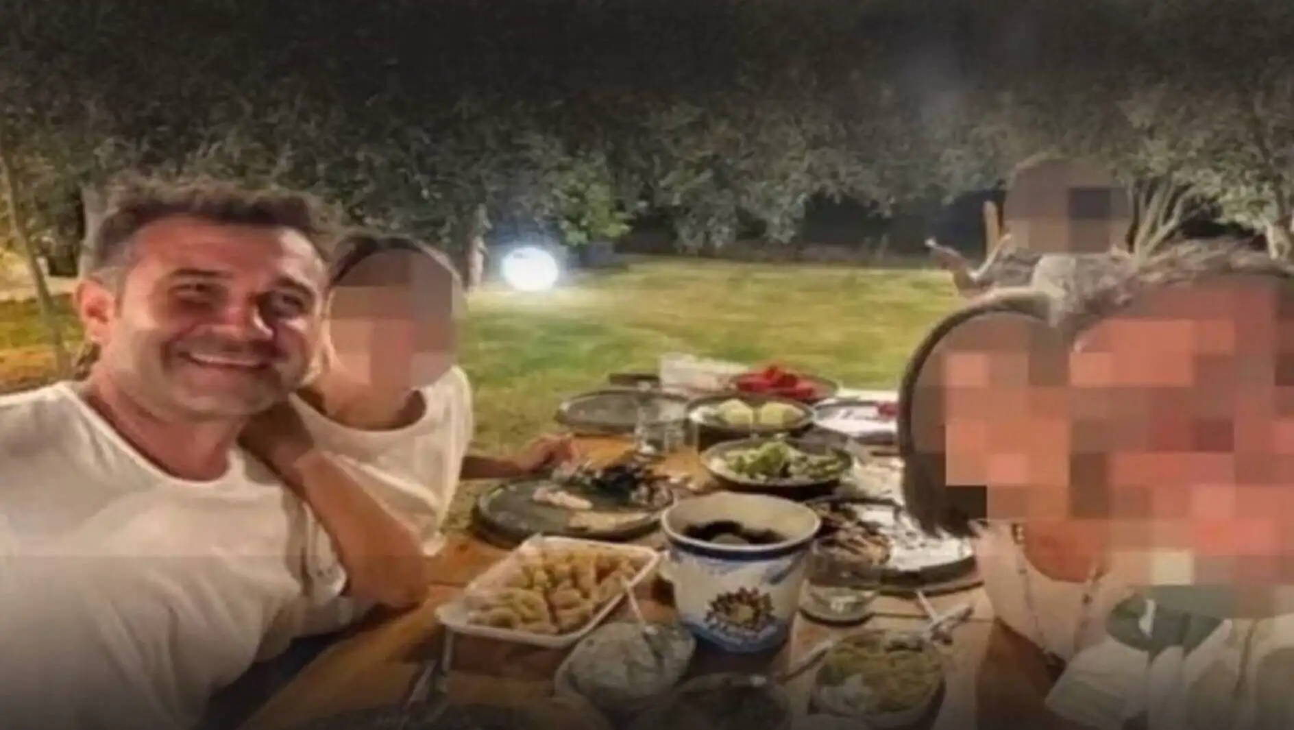 A group of people sitting at a table with food.
