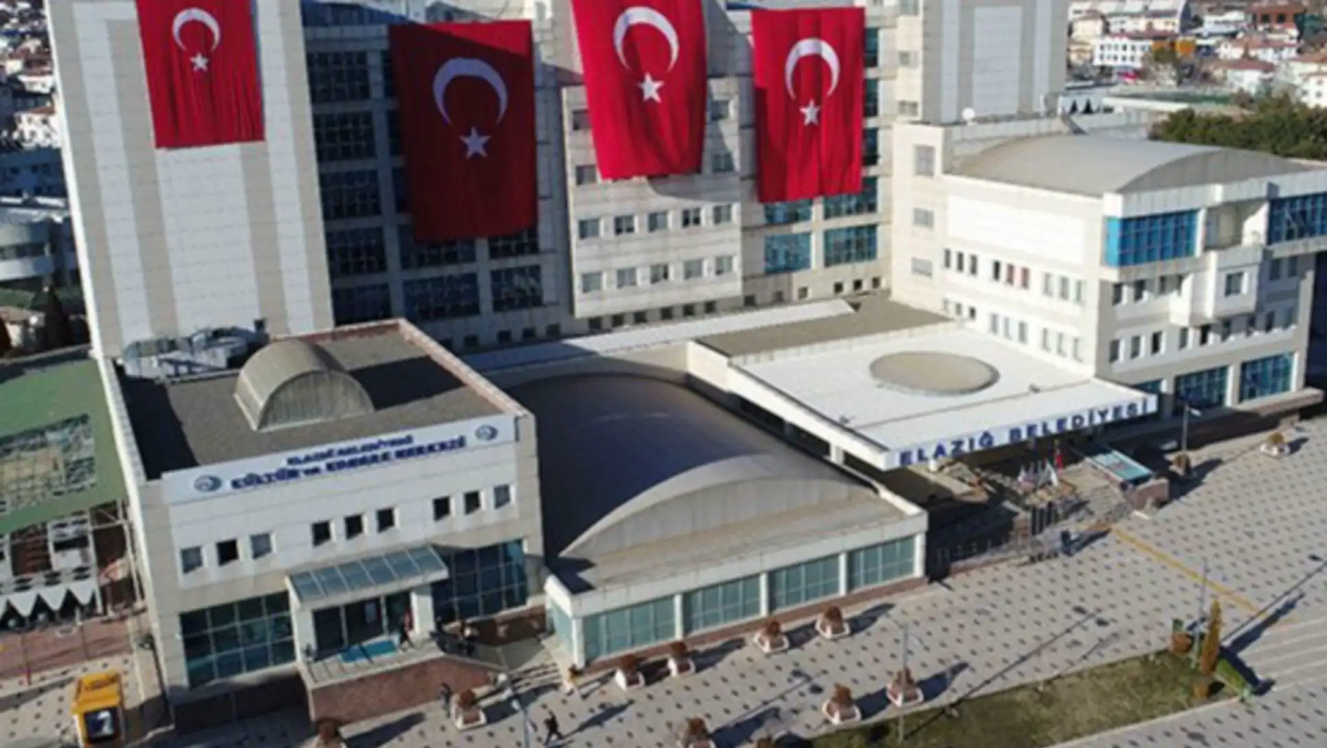Bir bina ve yanındaki bayraklar.