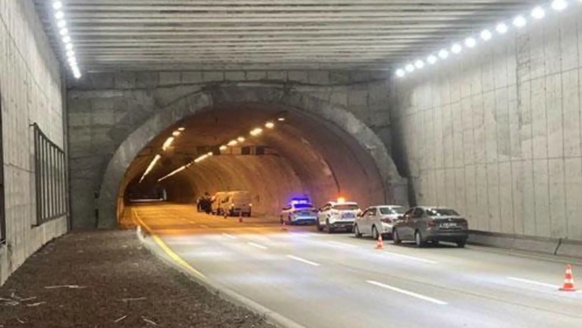 A tunnel with cars and lights.