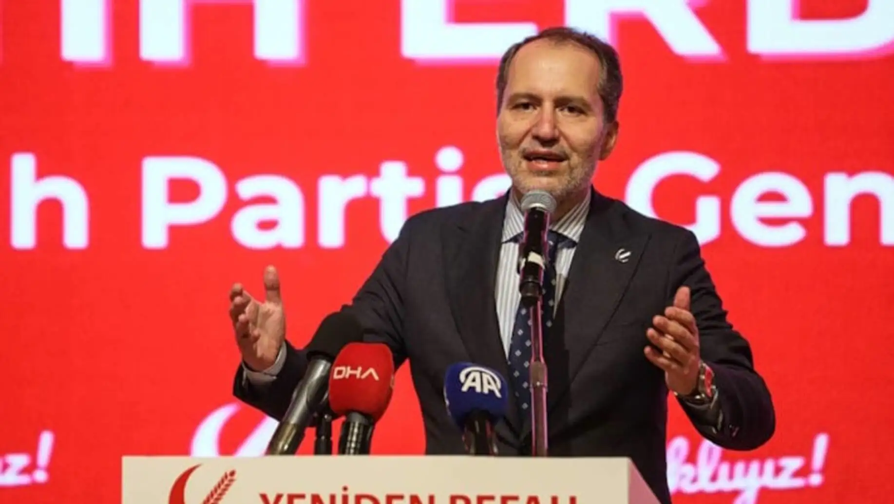 Fatih Erbakan bir podiumda mikrofonla konuşuyor. Fatih Erbakan bir podiumda mikrofonla konuşuyor.