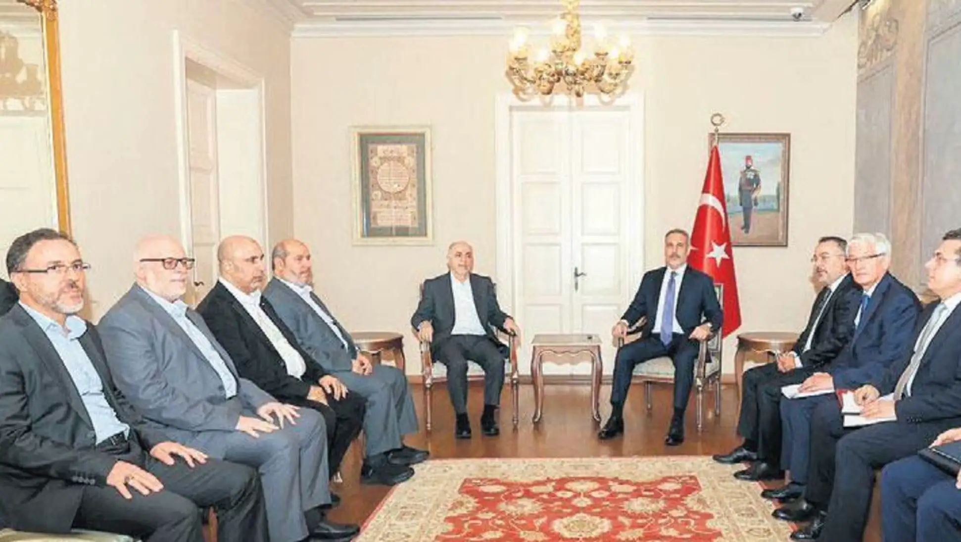 Bakanlar toplantısında bir grup erkek oturuyor.