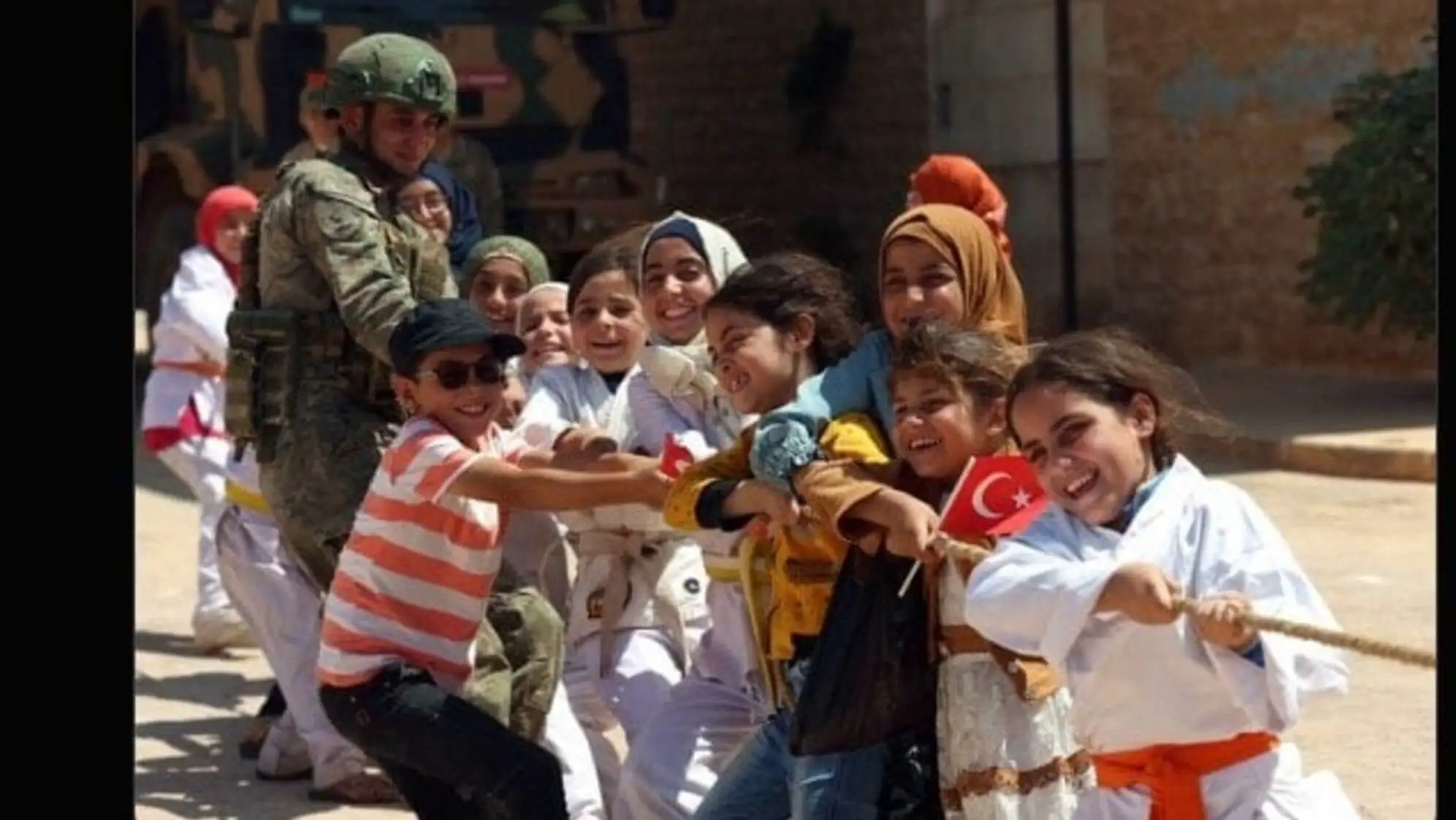 A group of children playing with a rope.