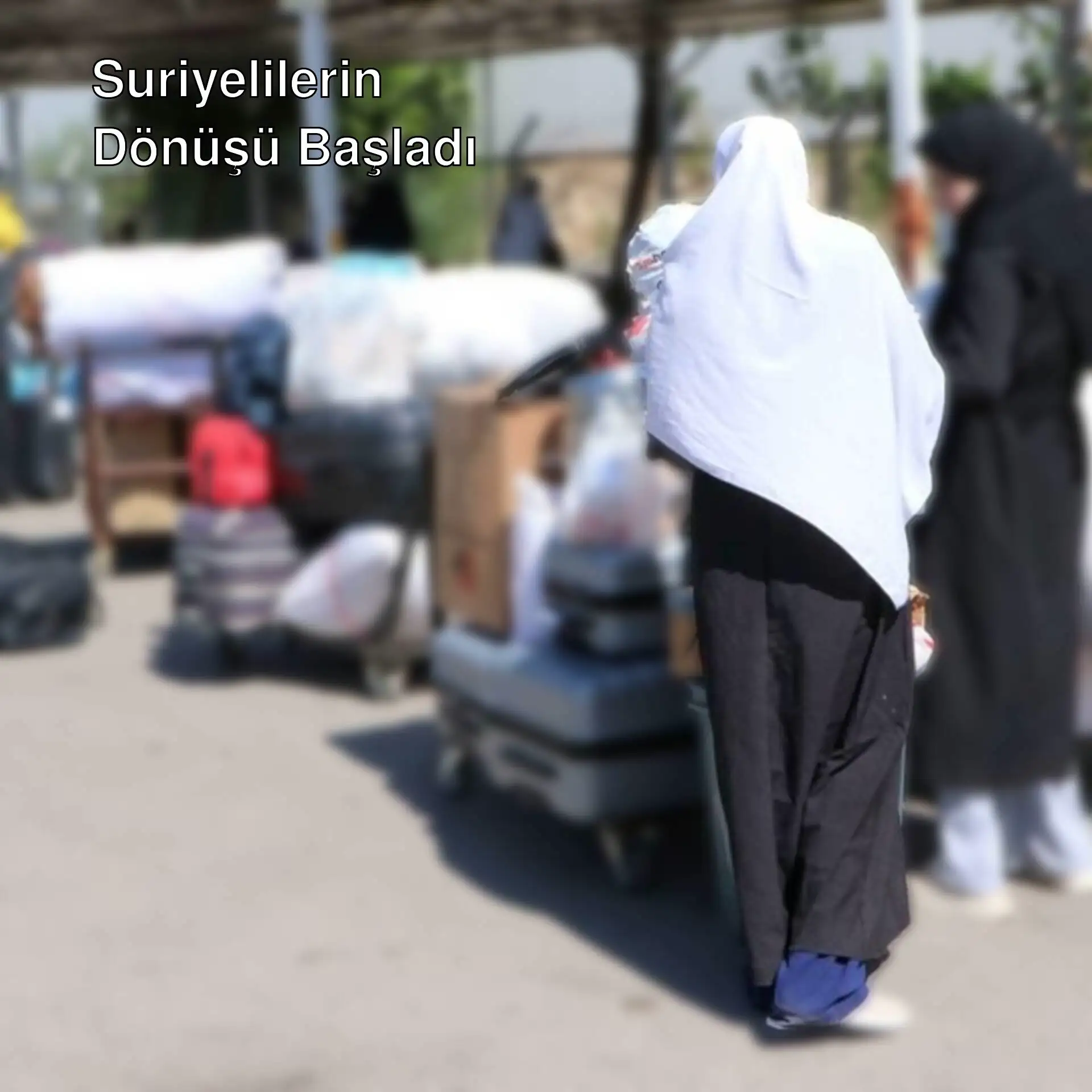 Suriyelilerin ülkelerine dönüşü sırasında iki kadın bagajlarının yanında duruyor. Suriyelilerin ülkelerine dönüşü sırasında iki kadın bagajlarının yanında duruyor.