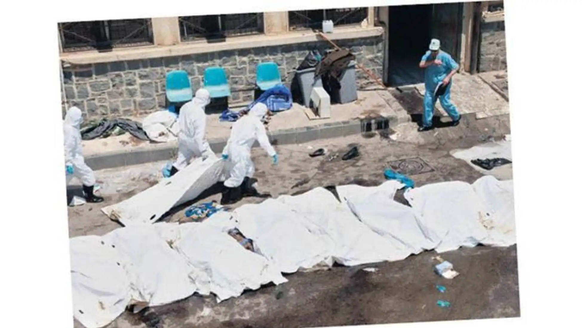 People in protective gear outside of a building. People in protective gear outside of a building.