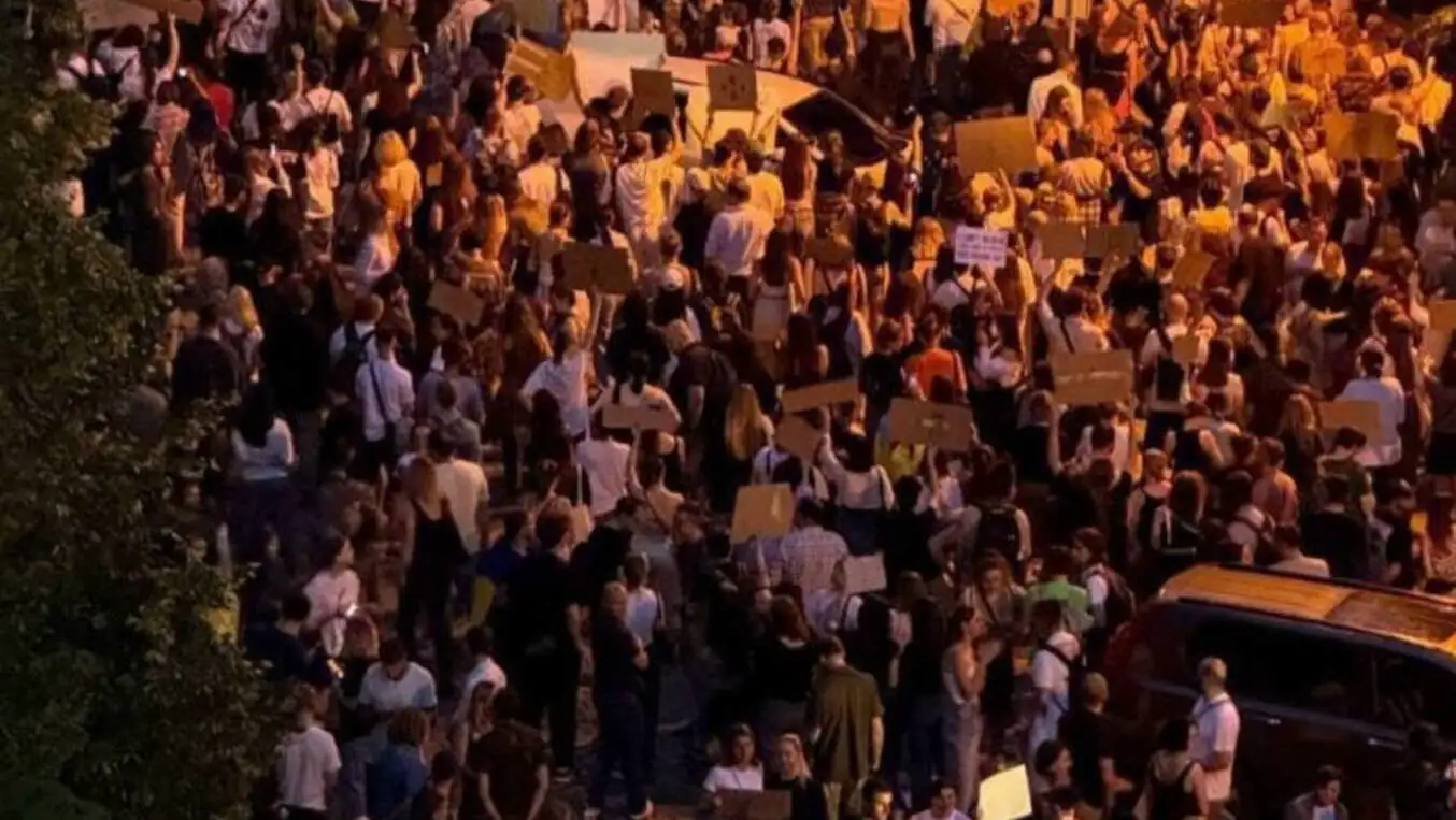 A group of people protesting in front of a building. A group of people protesting in front of a building.