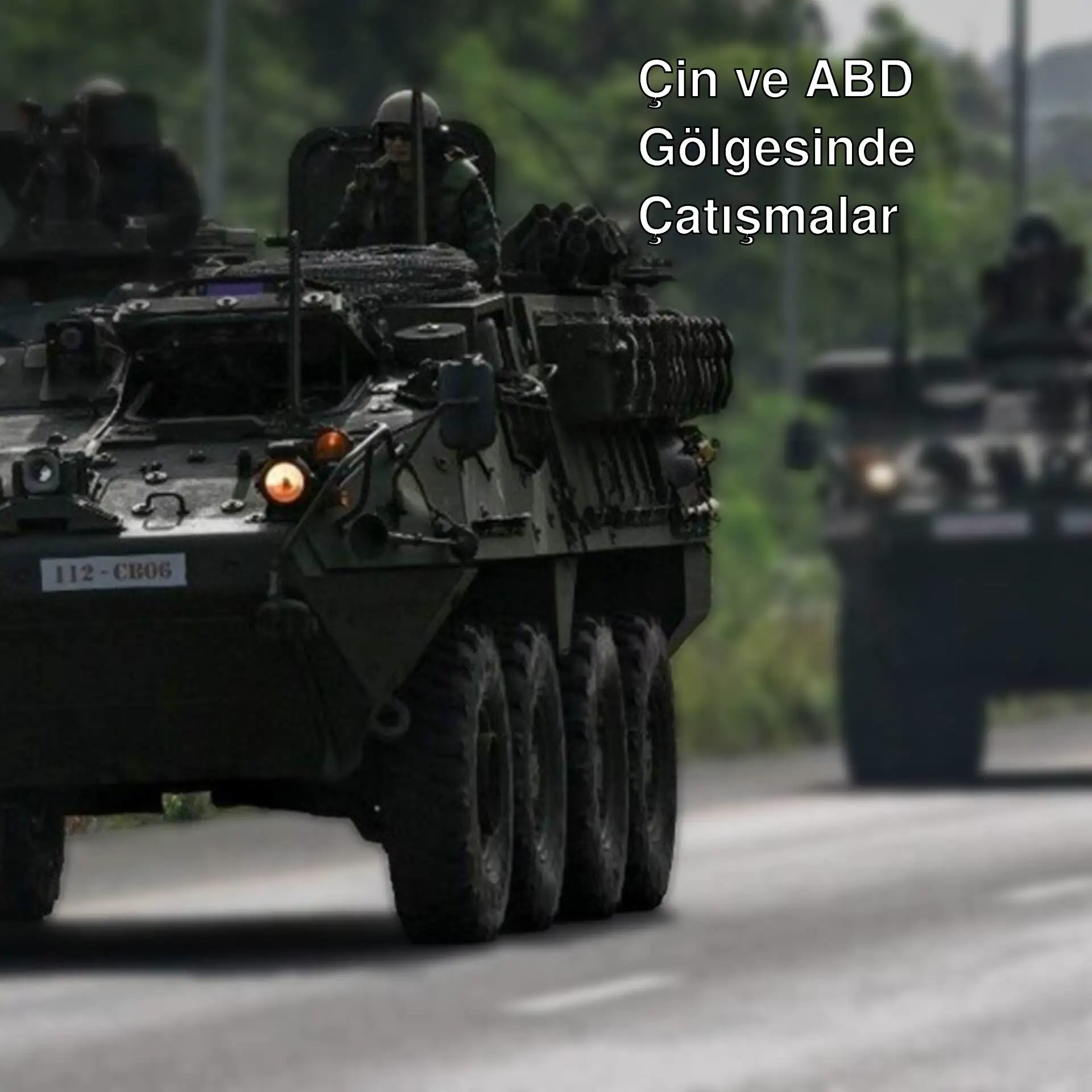 Askeri araçların bir yol boyunca ilerlediği görüntü.