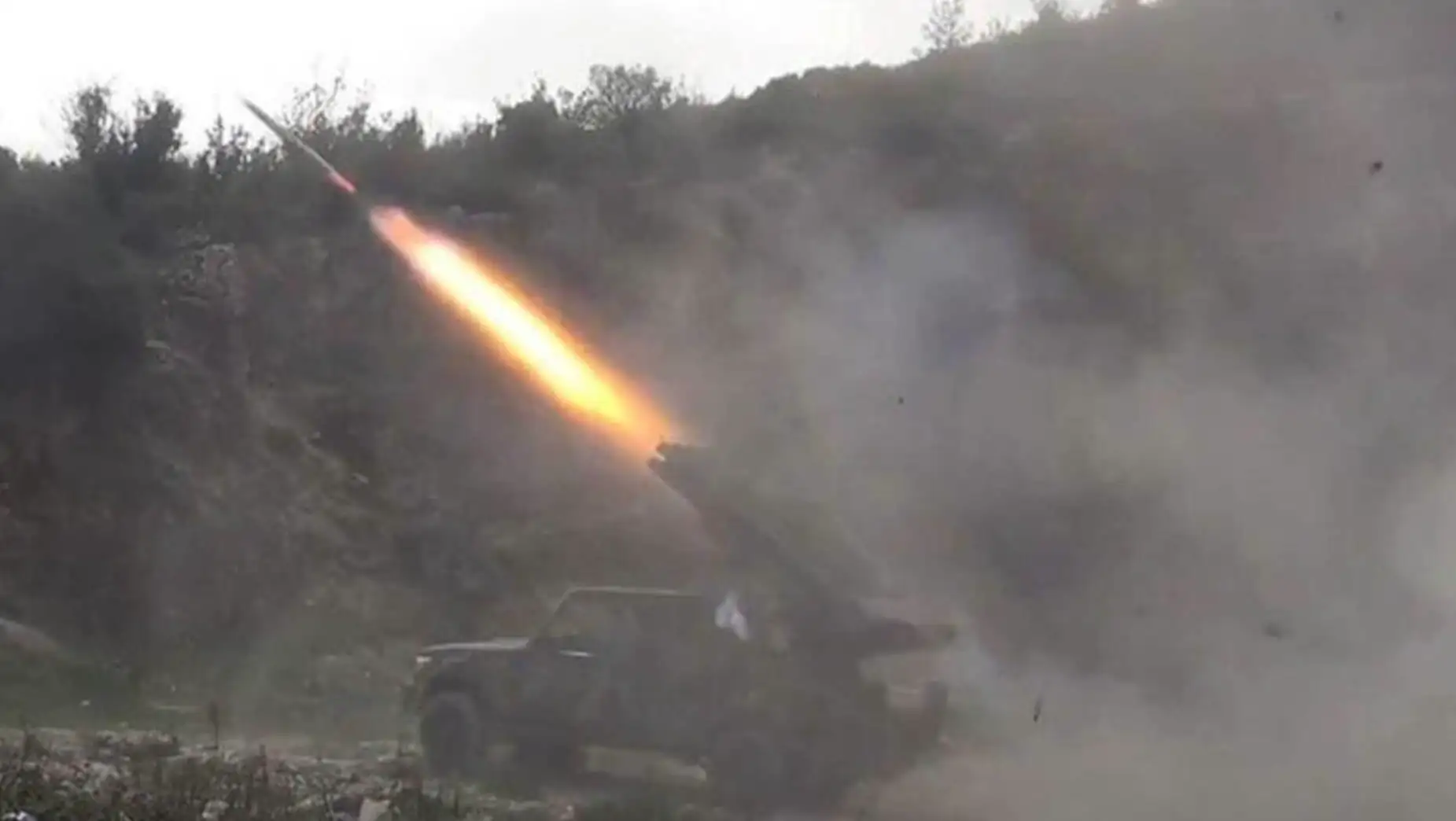 A military vehicle with a rocket launcher firing.