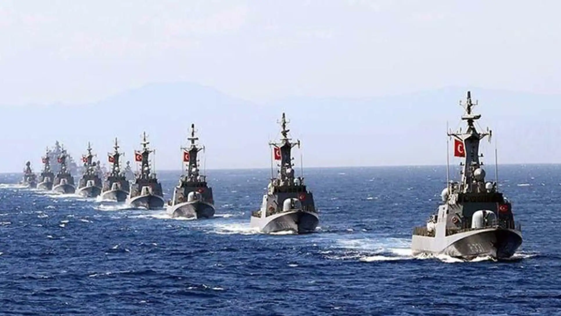 A group of military ships in the ocean. A group of military ships in the ocean.