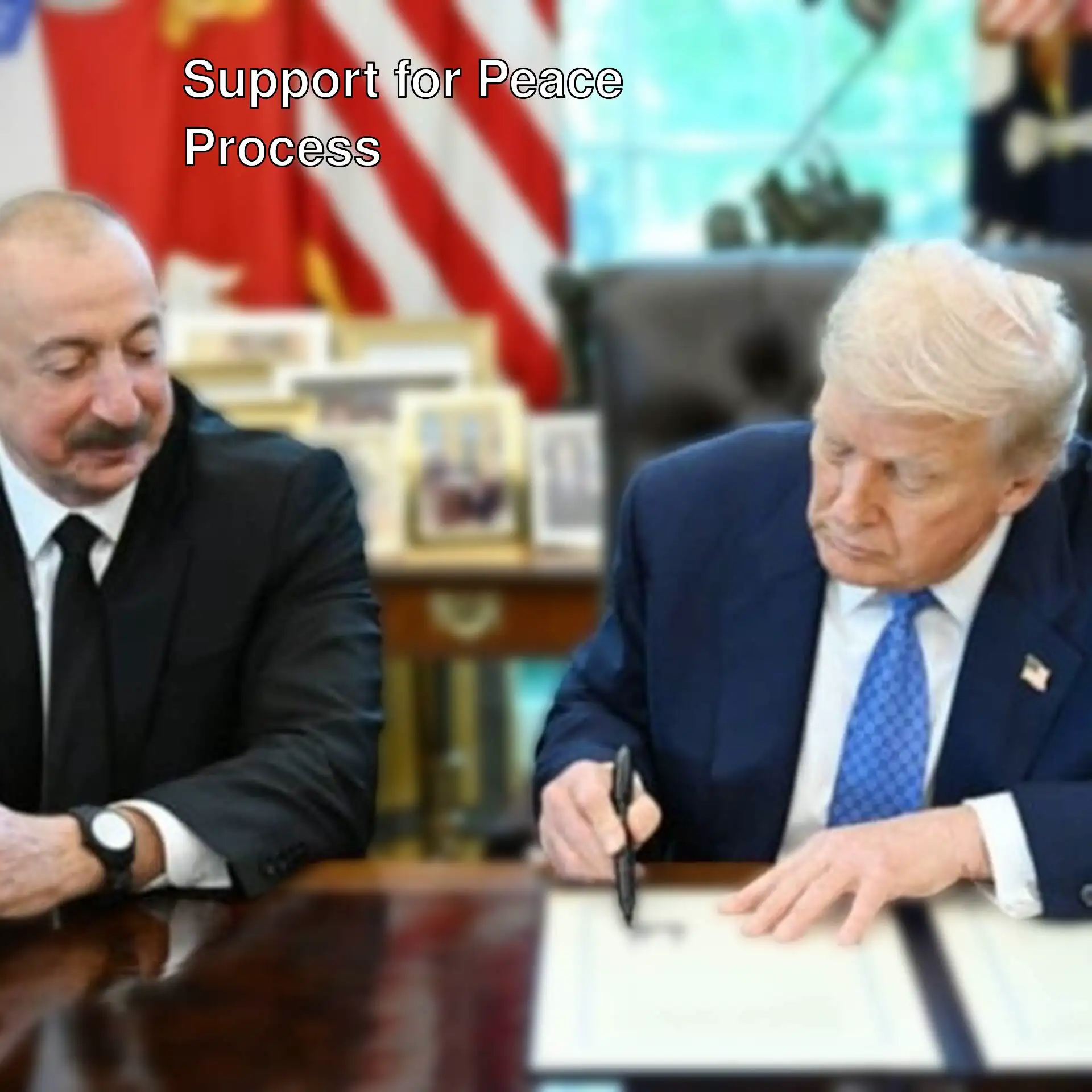 Two men sitting at a desk signing a document.