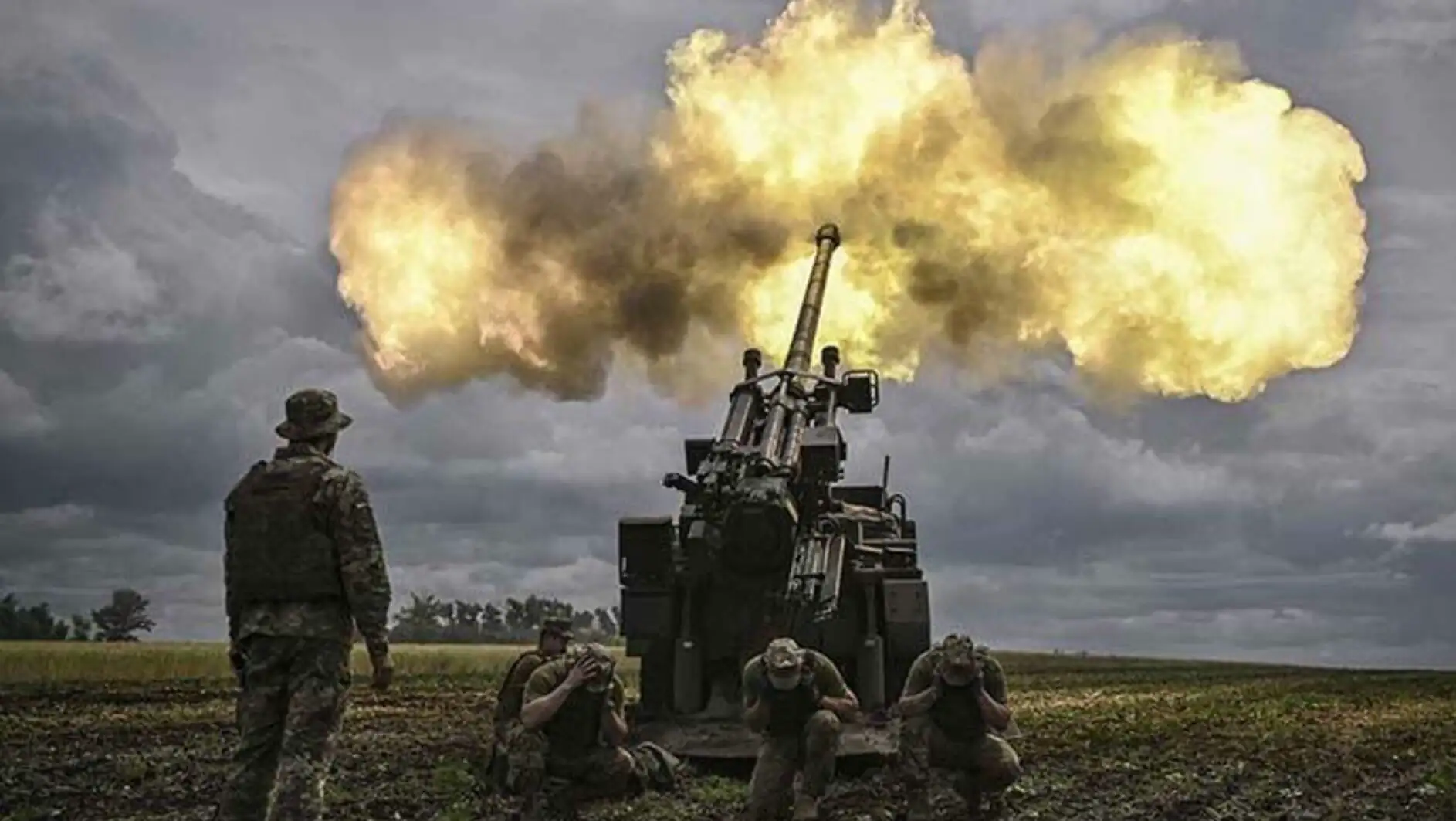 A group of people in military uniforms shooting a cannon. A group of people in military uniforms shooting a cannon.