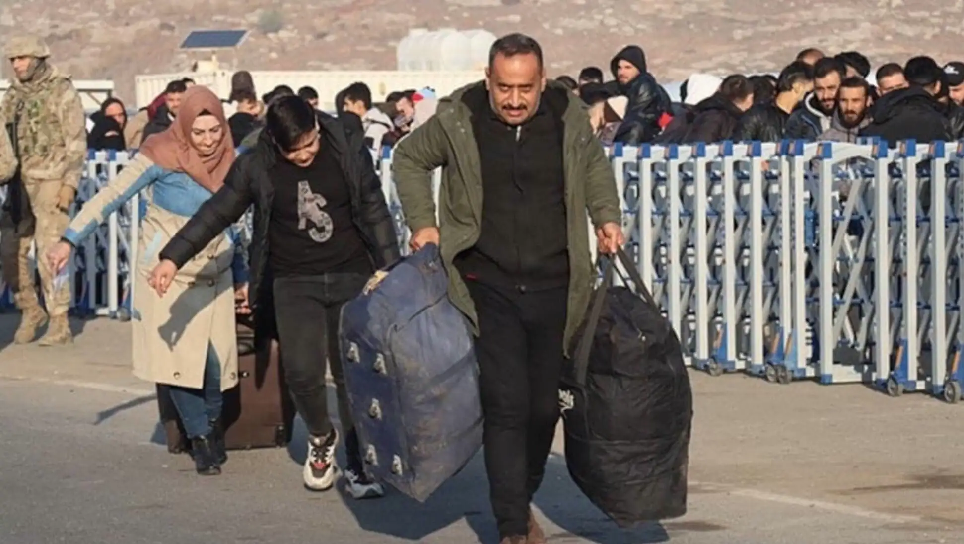 A group of people carrying luggage. A group of people carrying luggage.