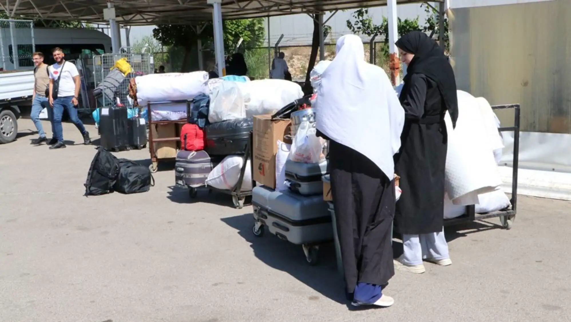 Two women standing next to luggage. Two women standing next to luggage.