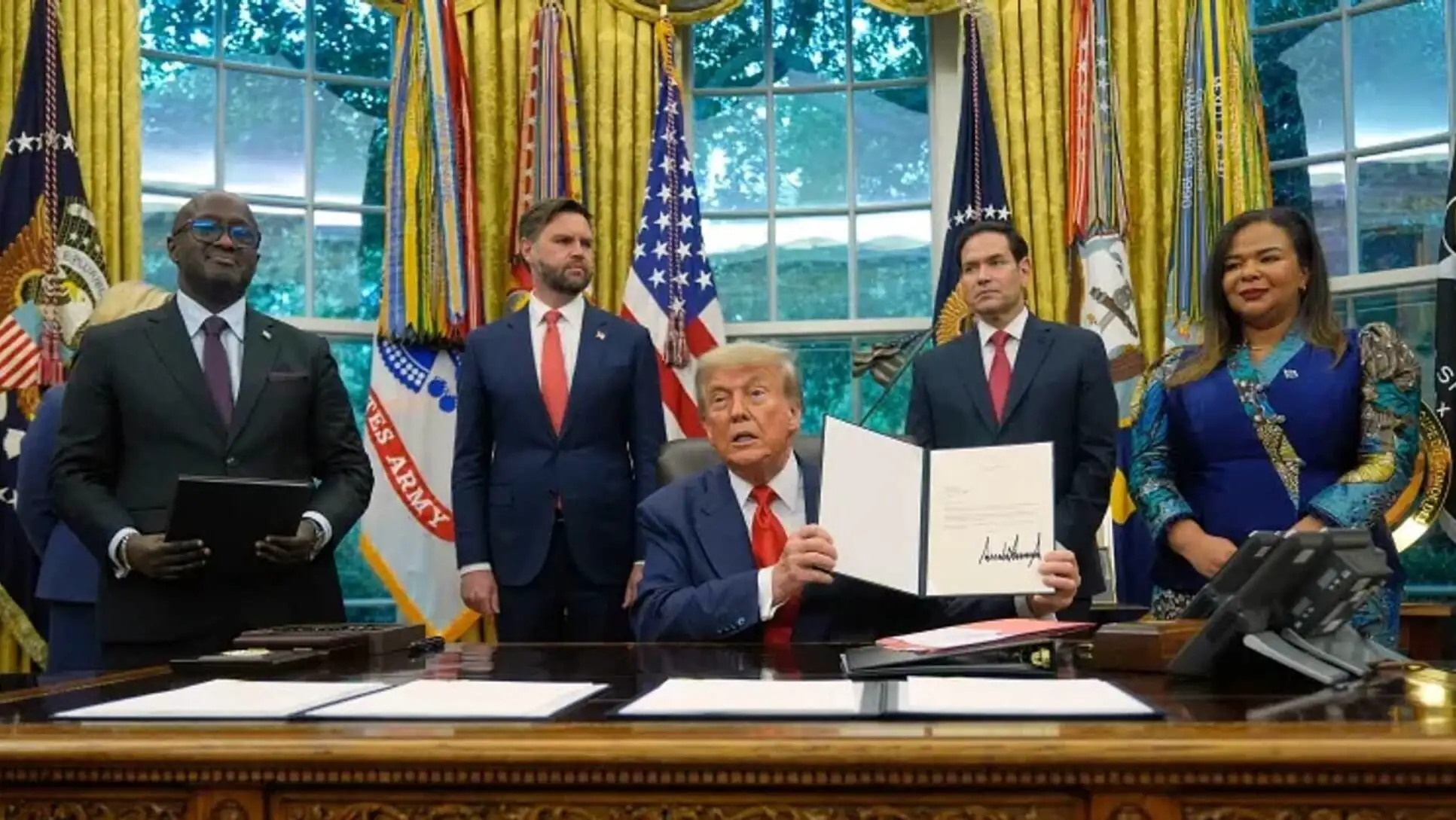 Trump with a group of men holding documents. Trump with a group of men holding documents.