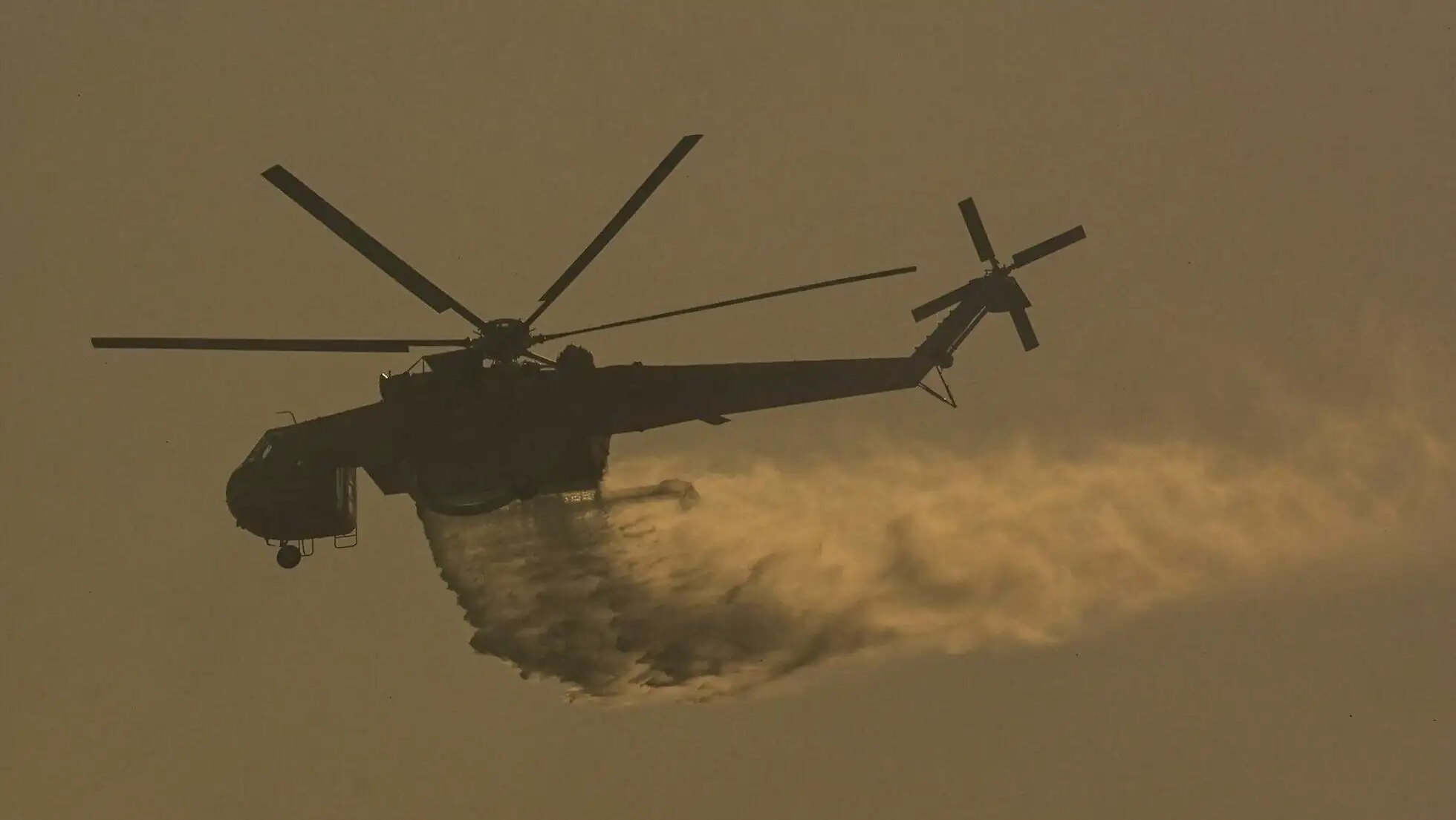 A helicopter dropping water from a fire. A helicopter dropping water from a fire.