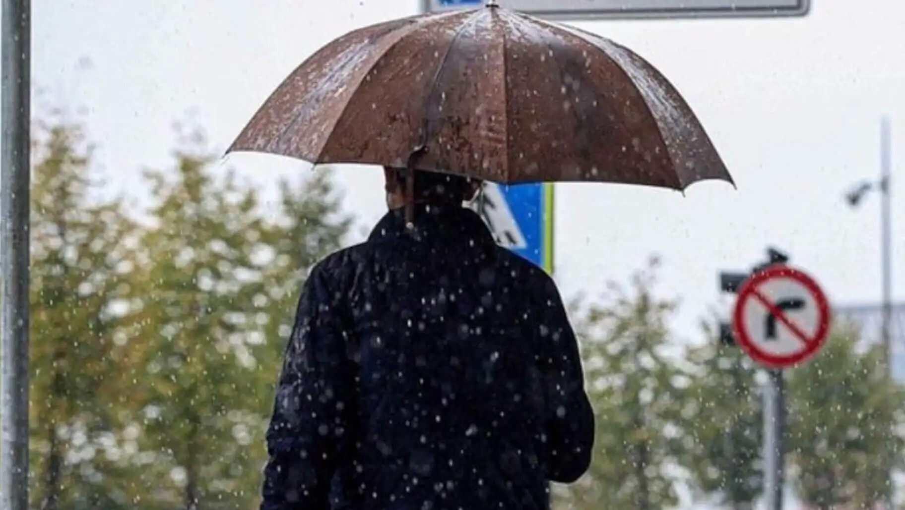 A person holding an umbrella in the snow. A person holding an umbrella in the snow.