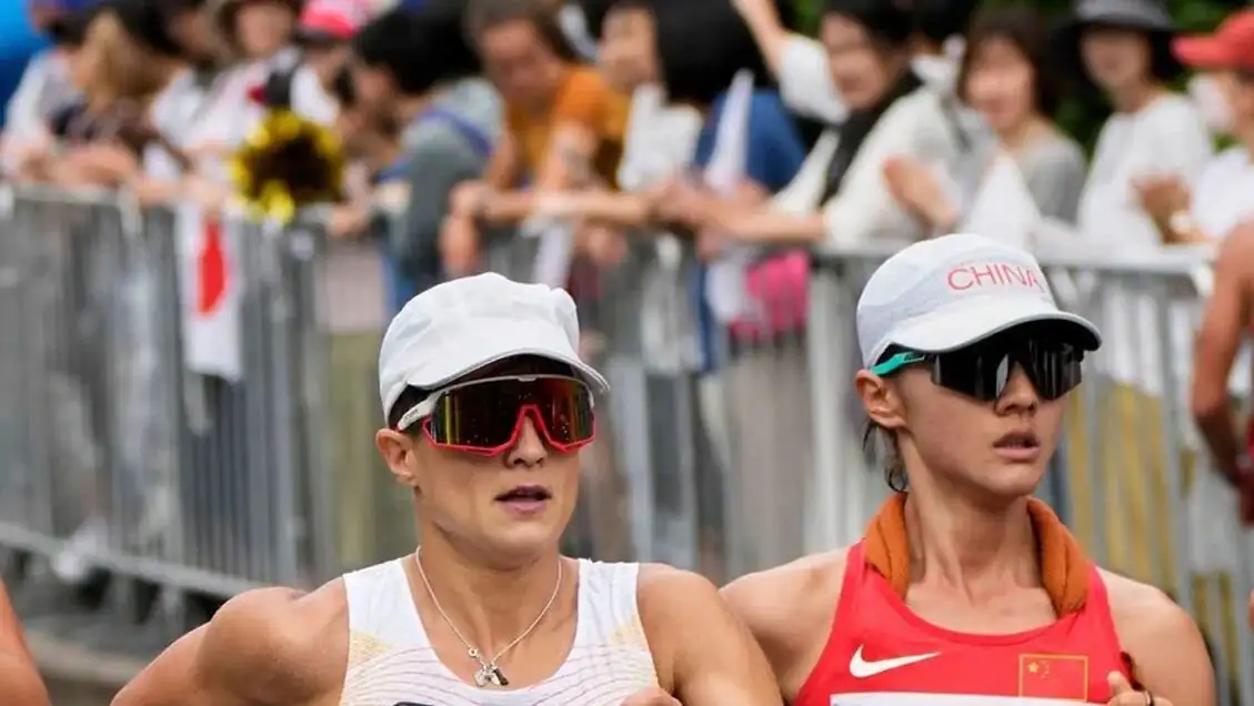 Two women running on a street.