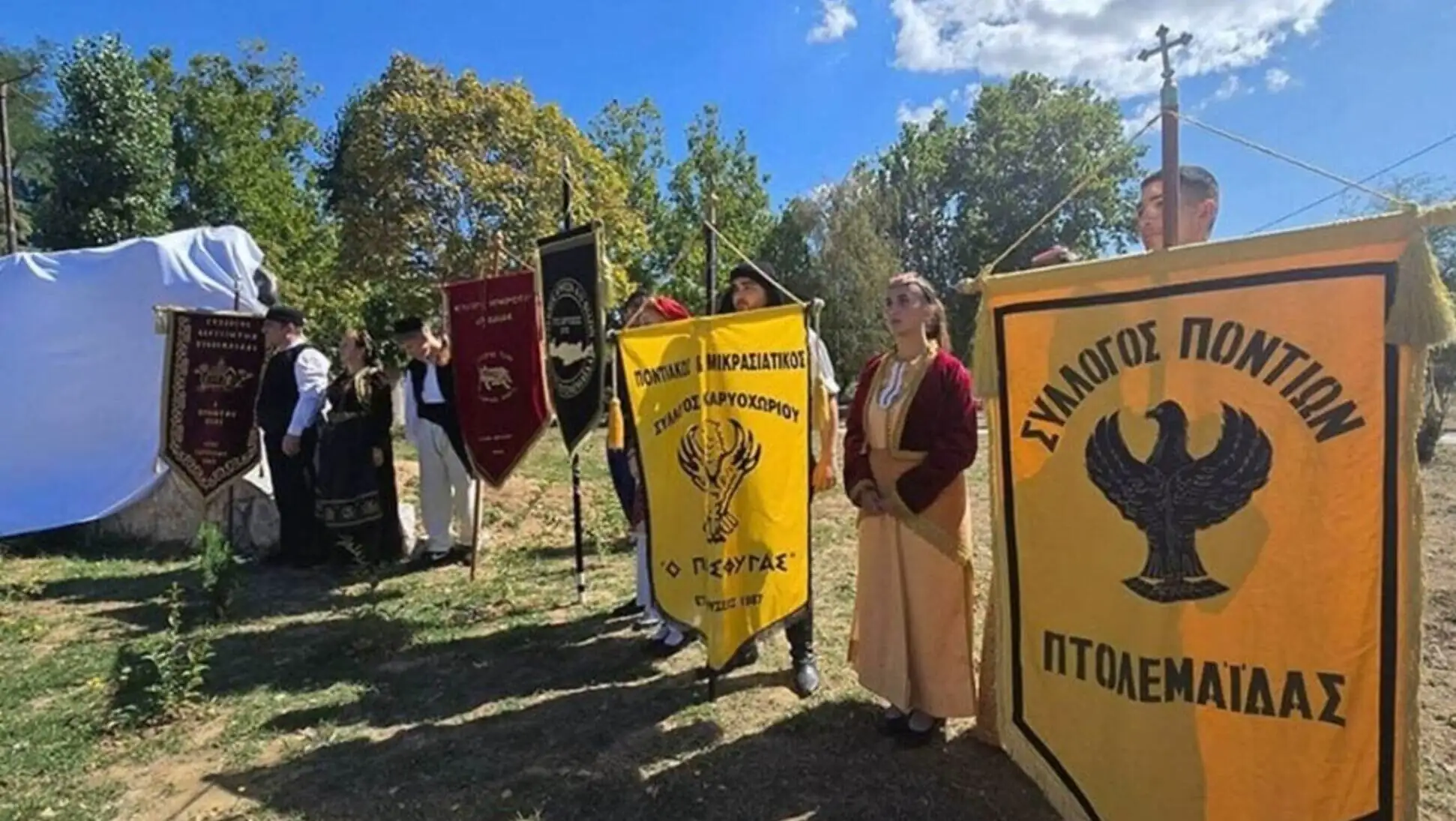 A group of people holding banners at the memorial ceremony.