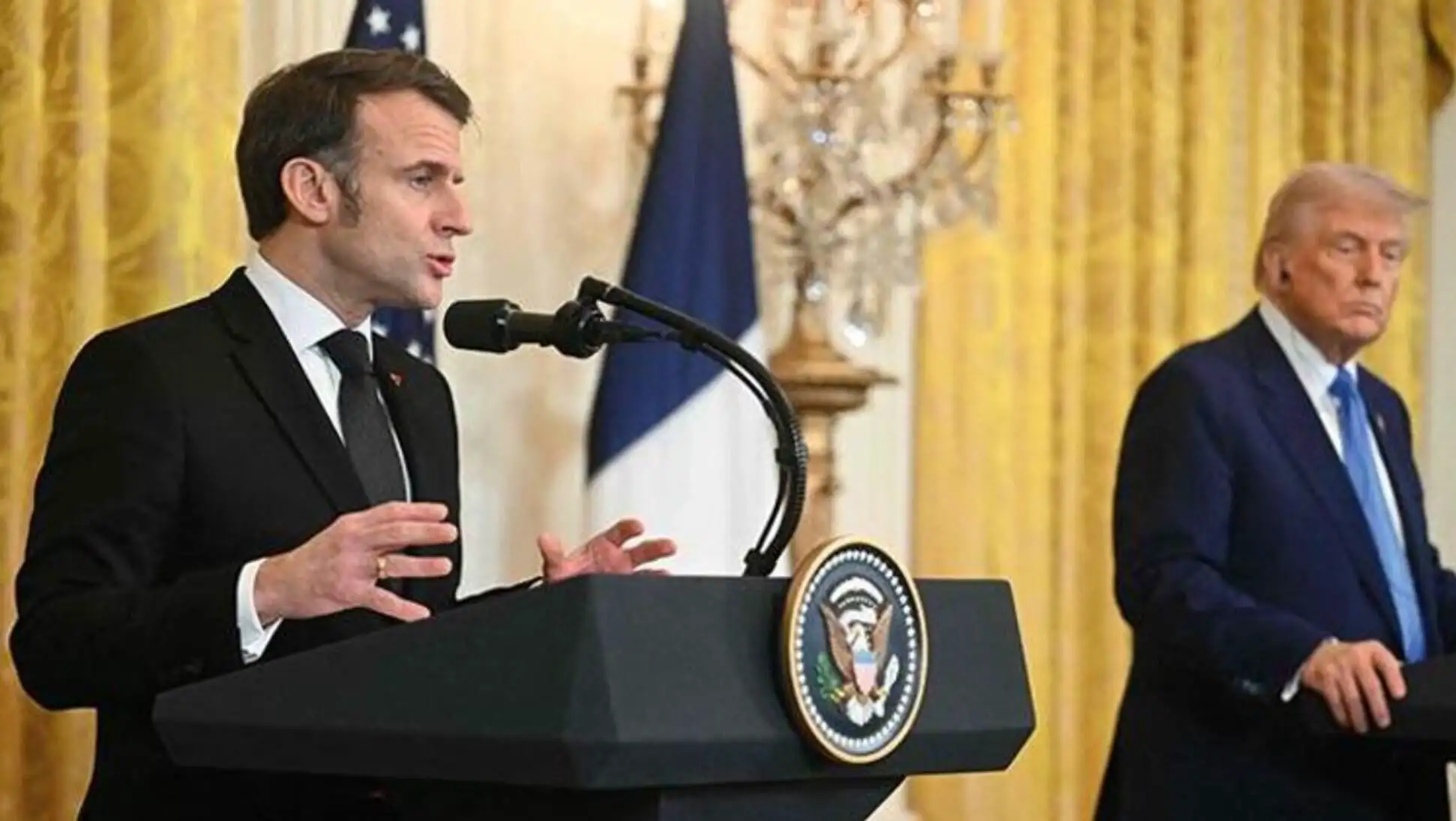 Trump speaking into a microphone.