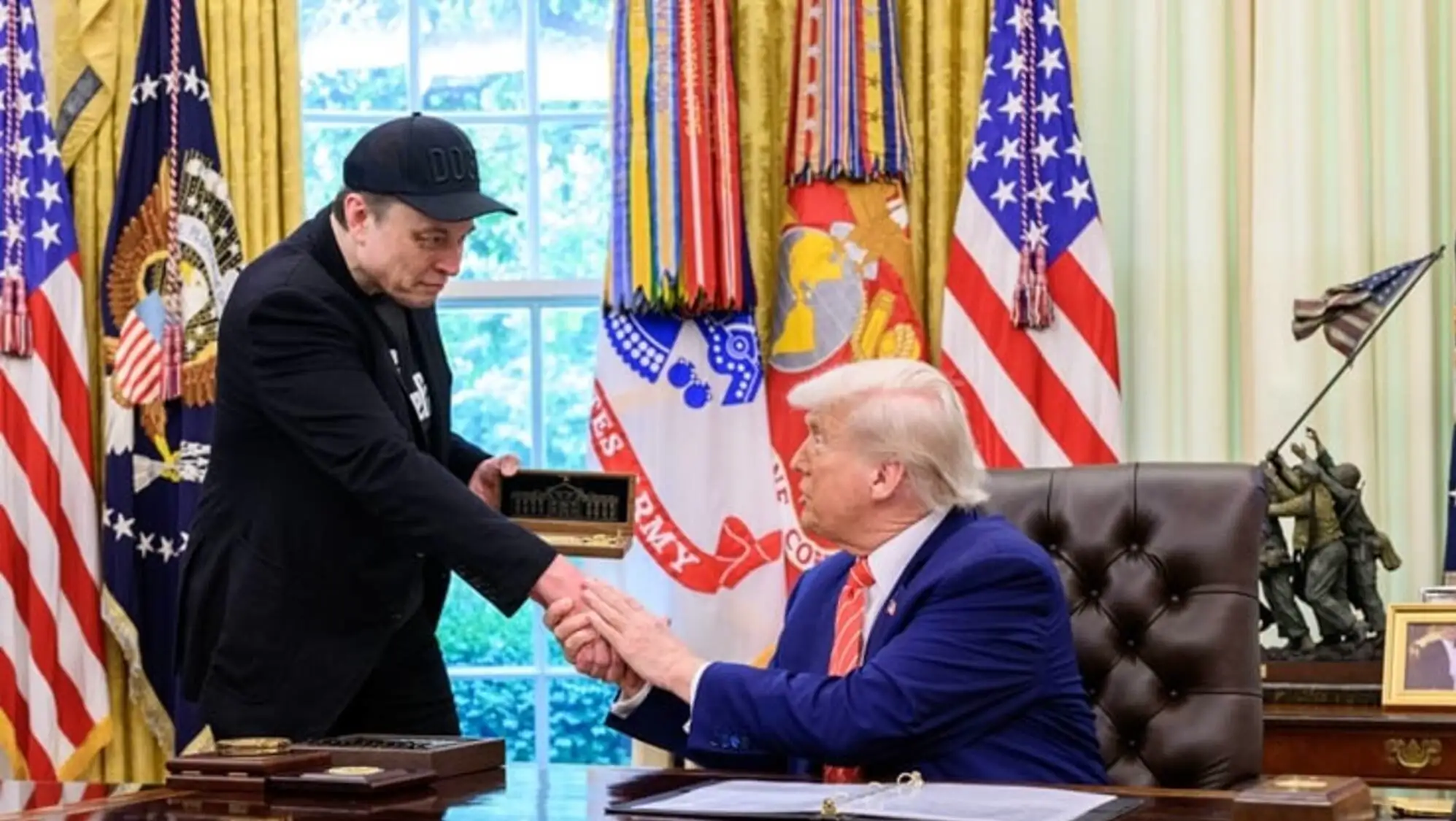 Elon Musk and Donald Trump shaking hands.
