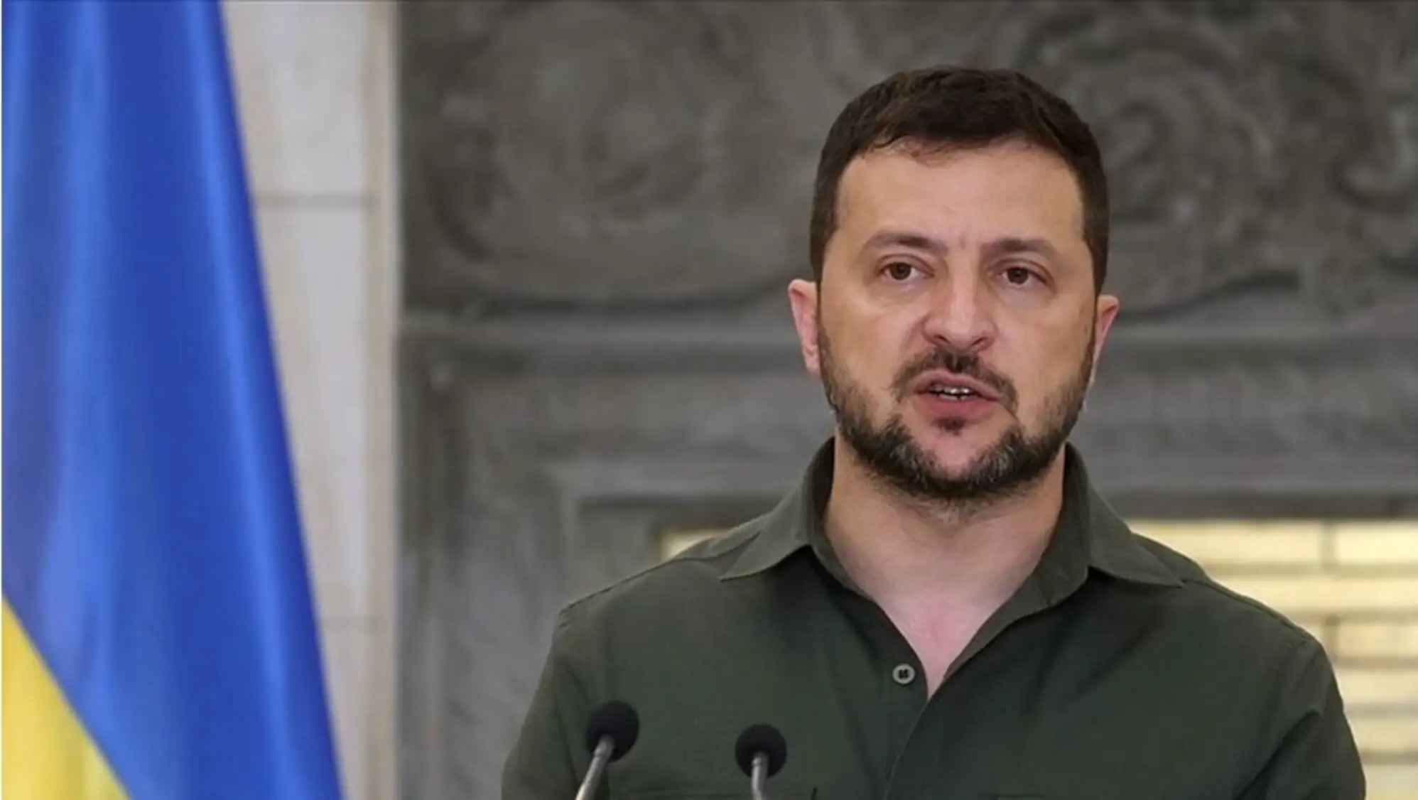 A man speaking into microphones.