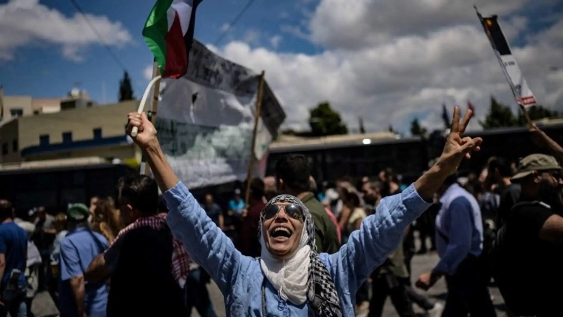 A woman smiling while holding a flag. A woman smiling while holding a flag.