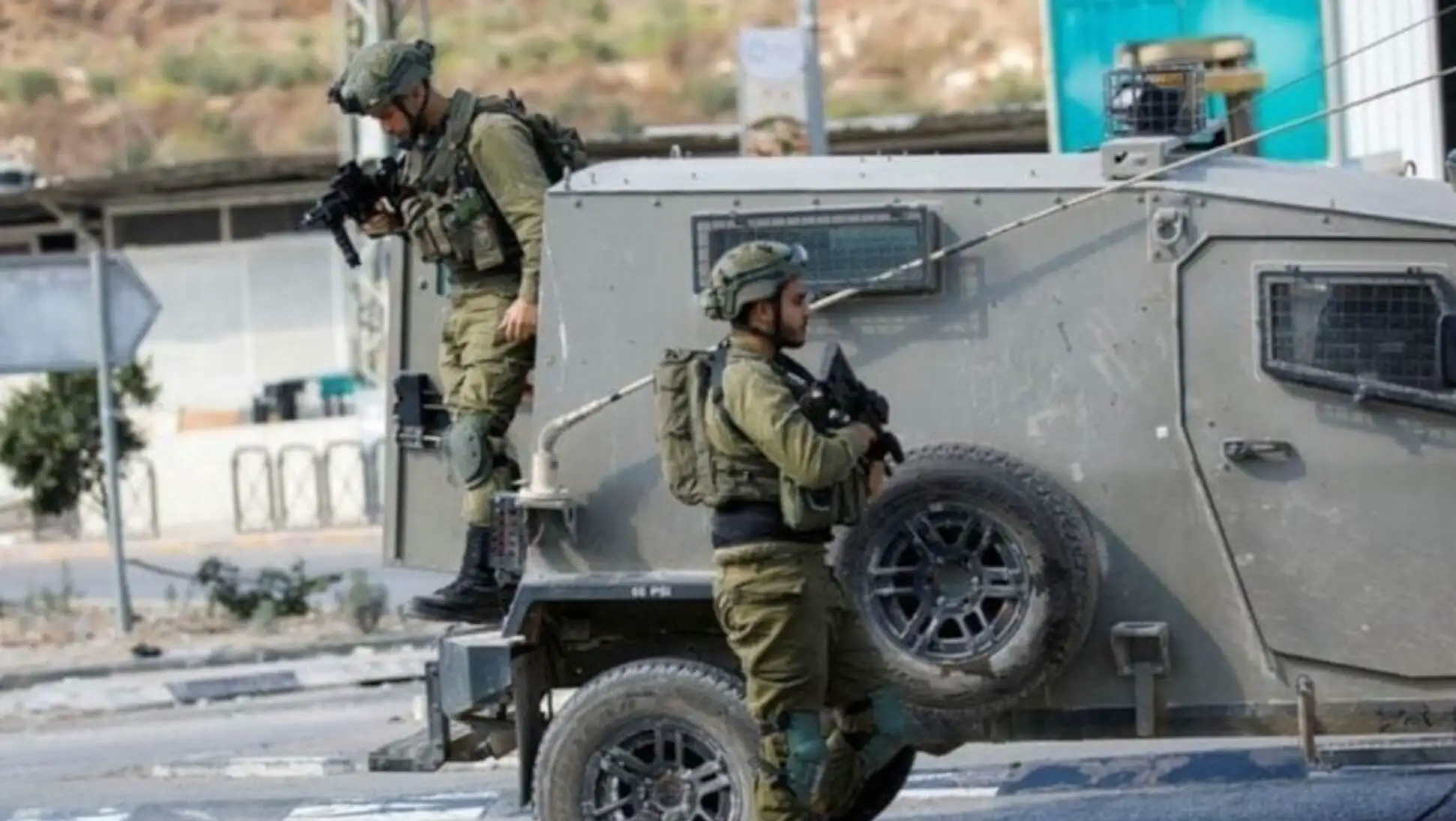 Israeli soldiers standing on a vehicle.