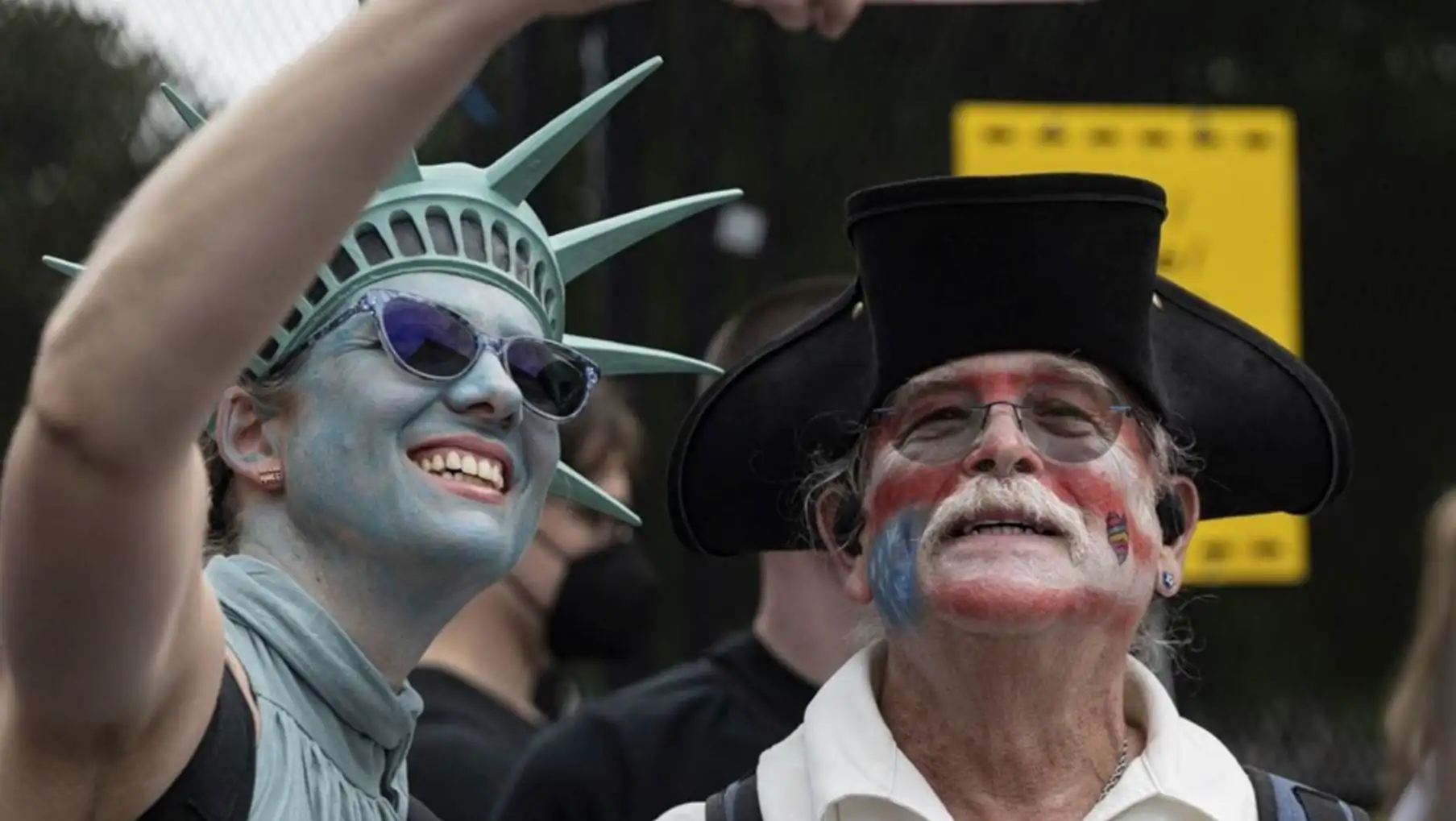 A woman taking a selfie with a man in a hat. A woman taking a selfie with a man in a hat.
