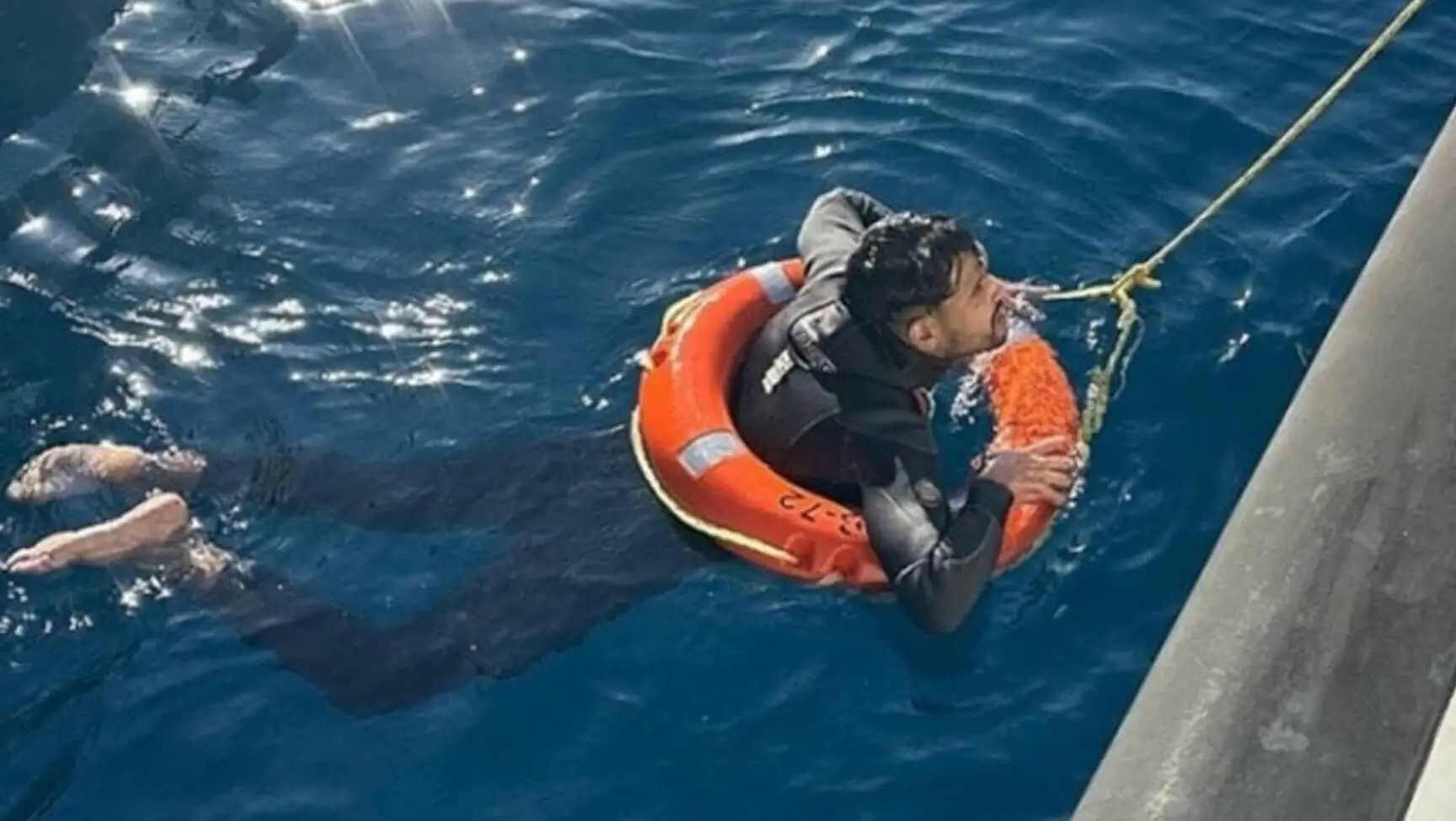 A man in a life preserver in the water. A man in a life preserver in the water.