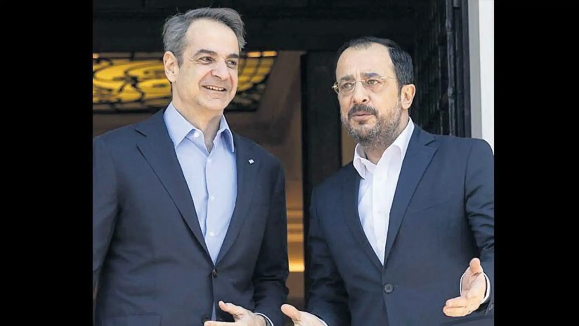 Two men in suits standing next to each other. Two men in suits standing next to each other.