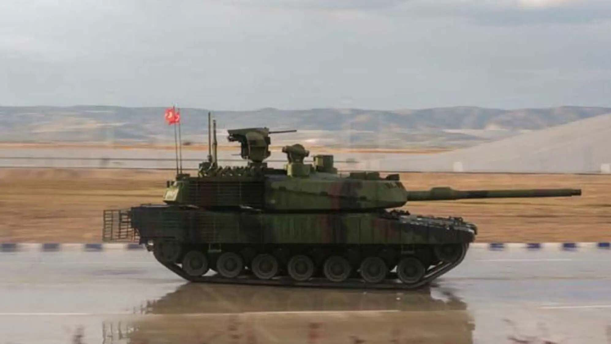 A military tank on a wet road.