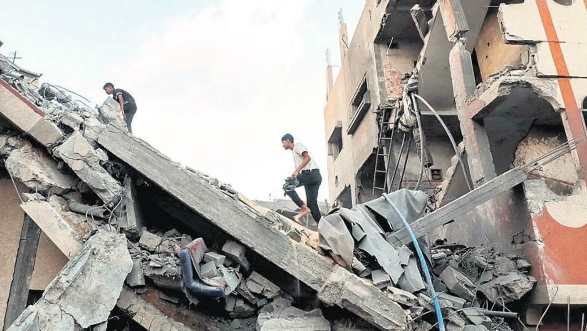 A group of men walking on a collapsed building.
