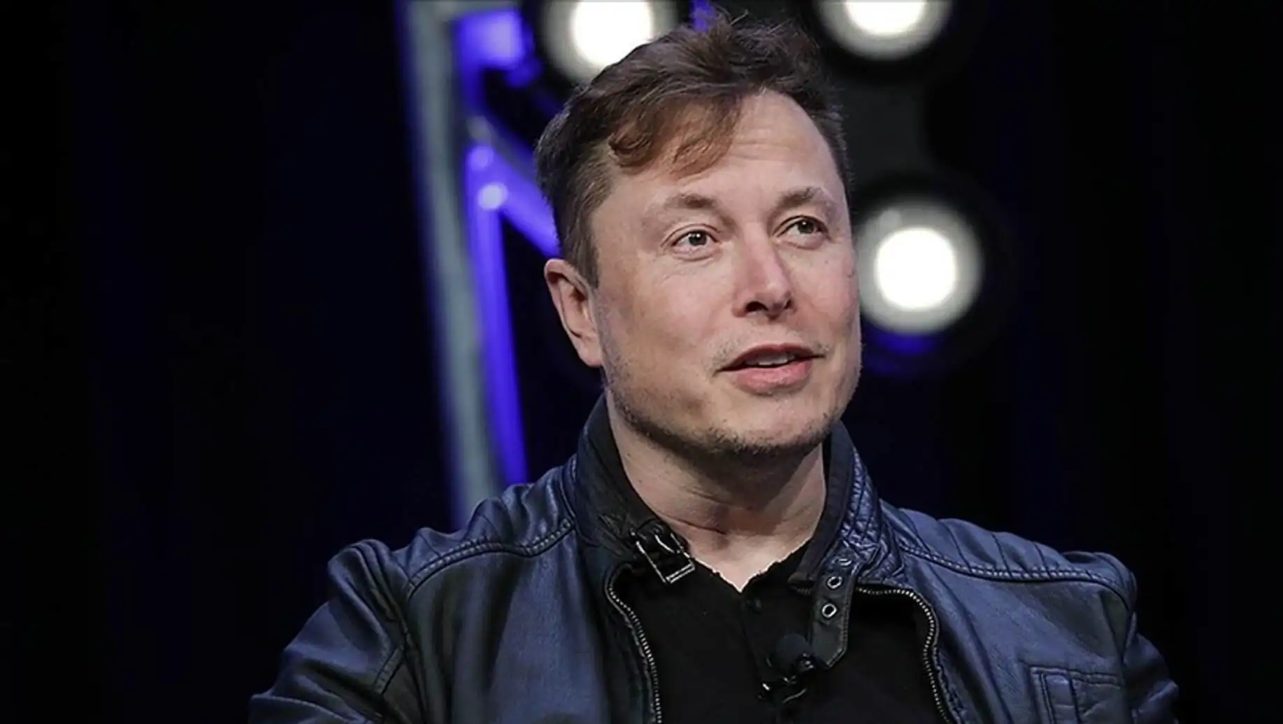 Elon Musk deri ceket ile poz veriyor.