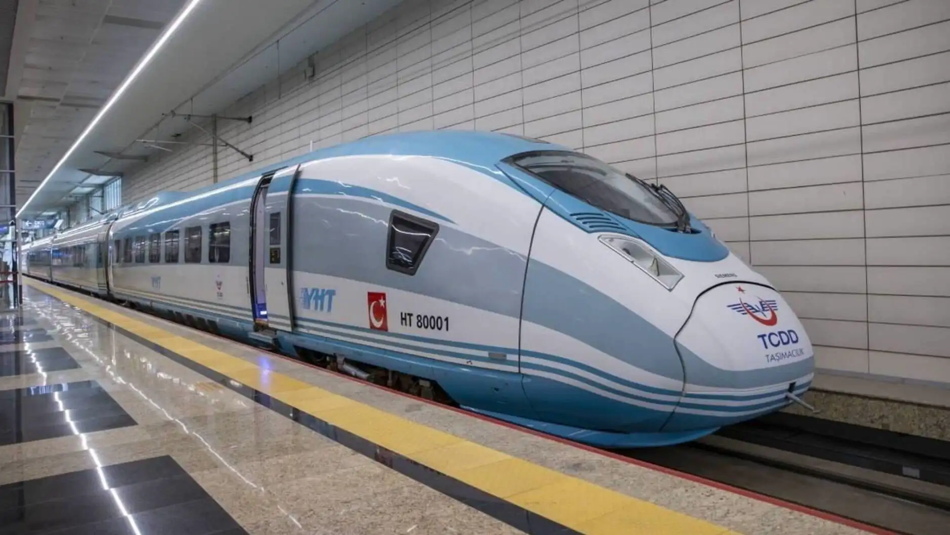 A blue and white train in a station A blue and white train in a station