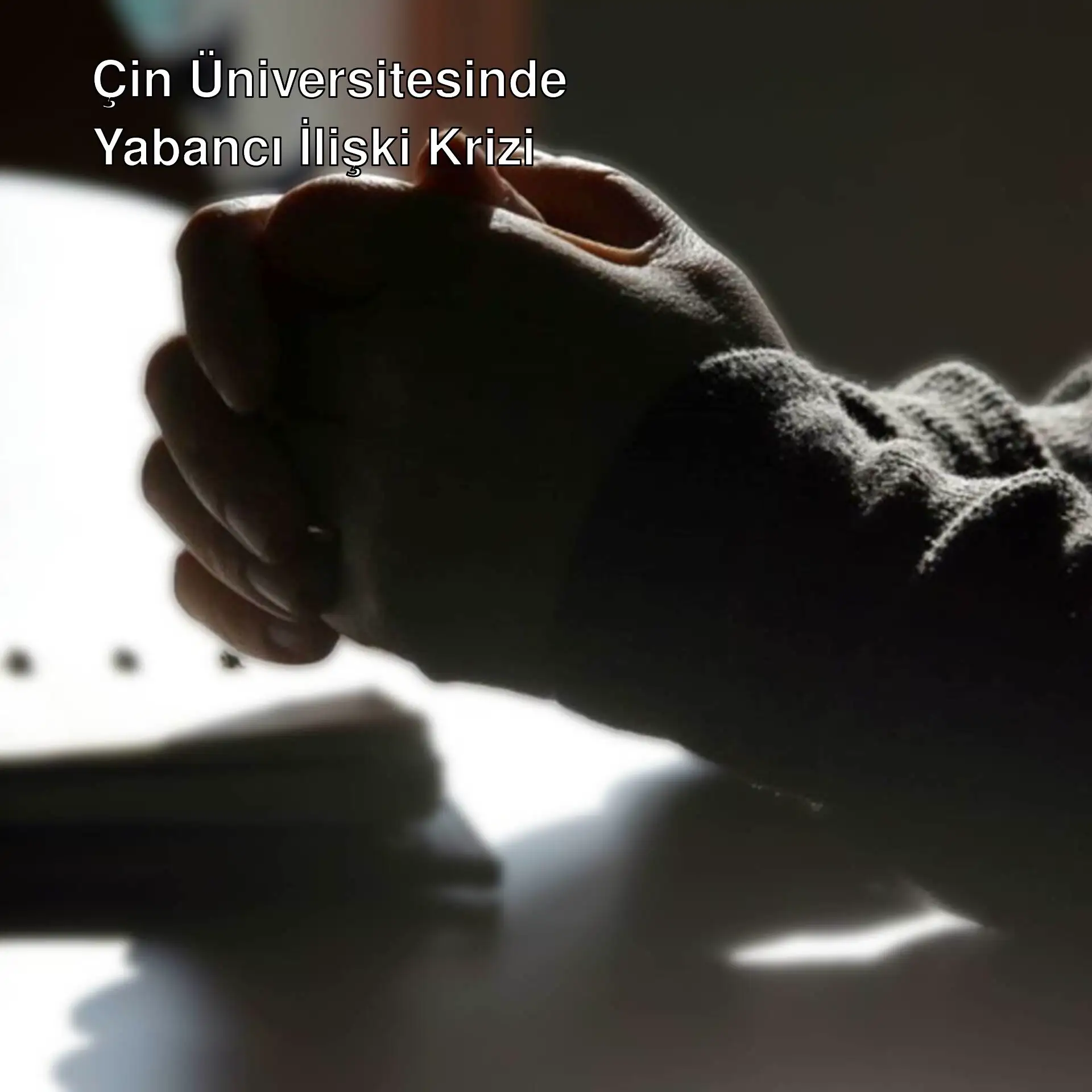 Bir kişinin elleri masanın üzerinde katlanmış. Bir kişinin elleri masanın üzerinde katlanmış.